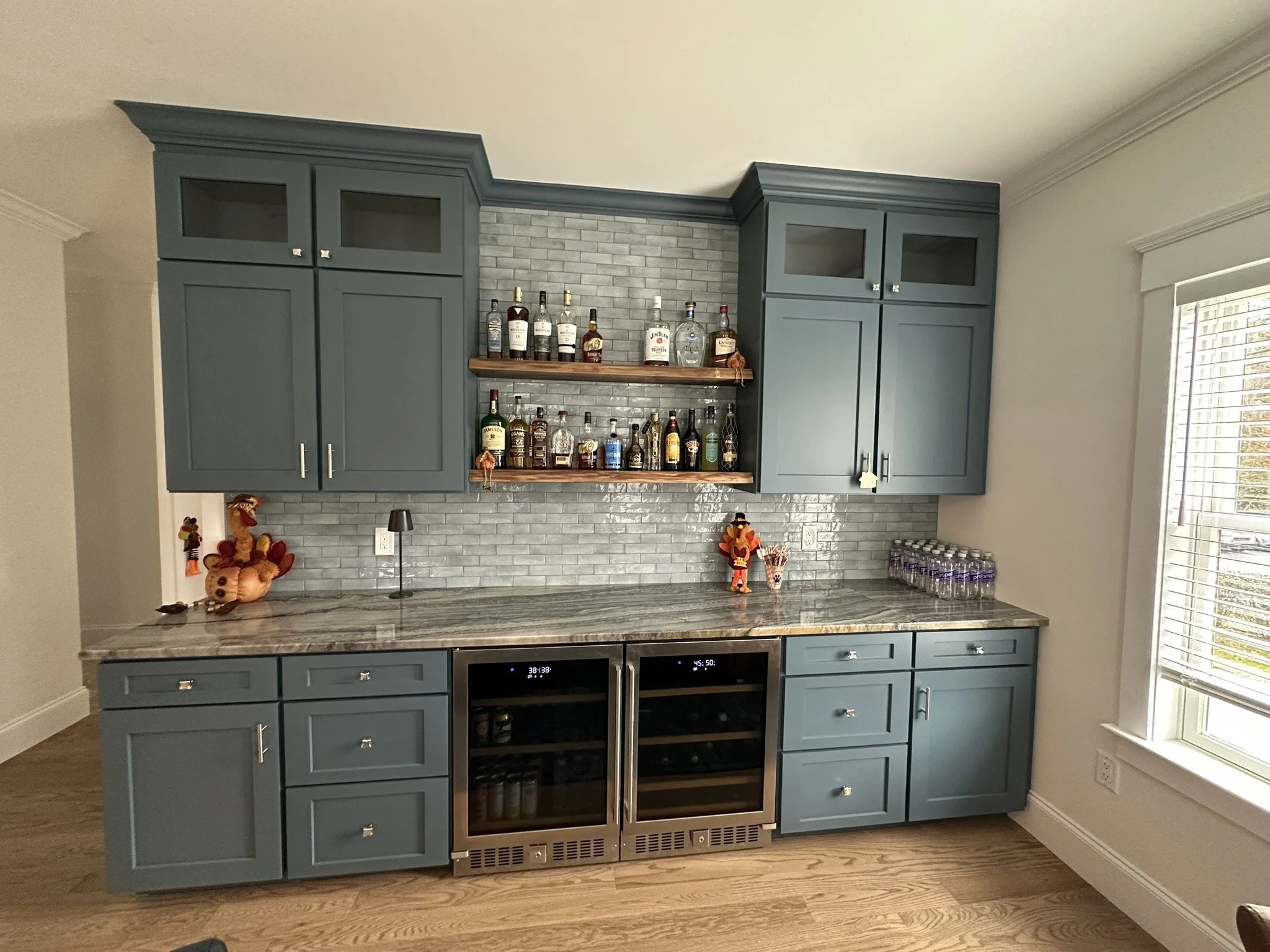 Custom dry bar with gray-blue cabinetry and beverage refrigerators