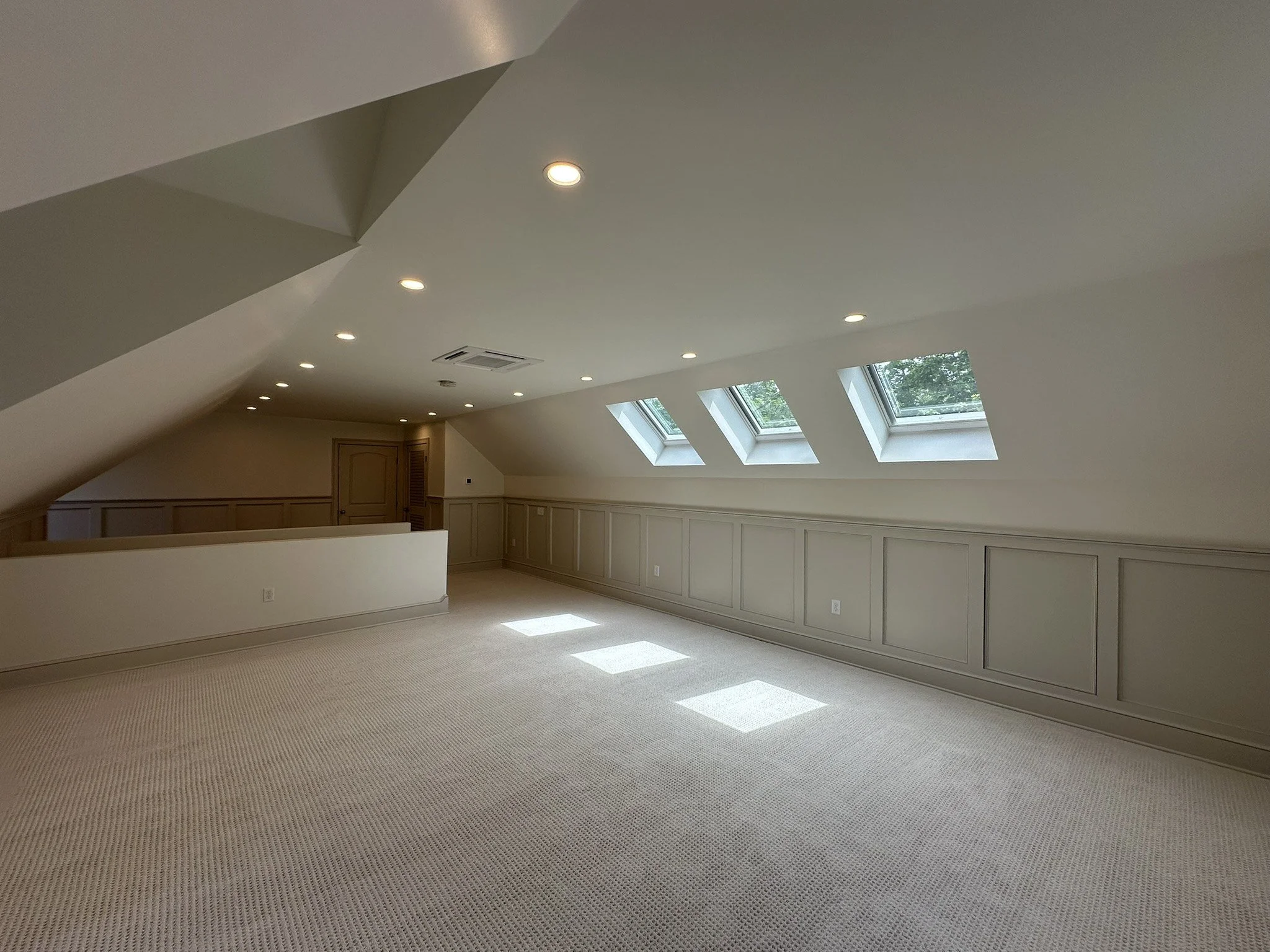 Finished attic with skylights, carpet and custom paneled knee walls