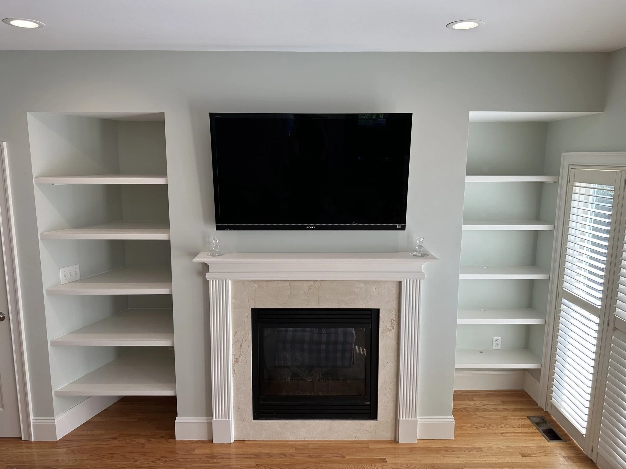 Custom shelves added beside an existing fireplace