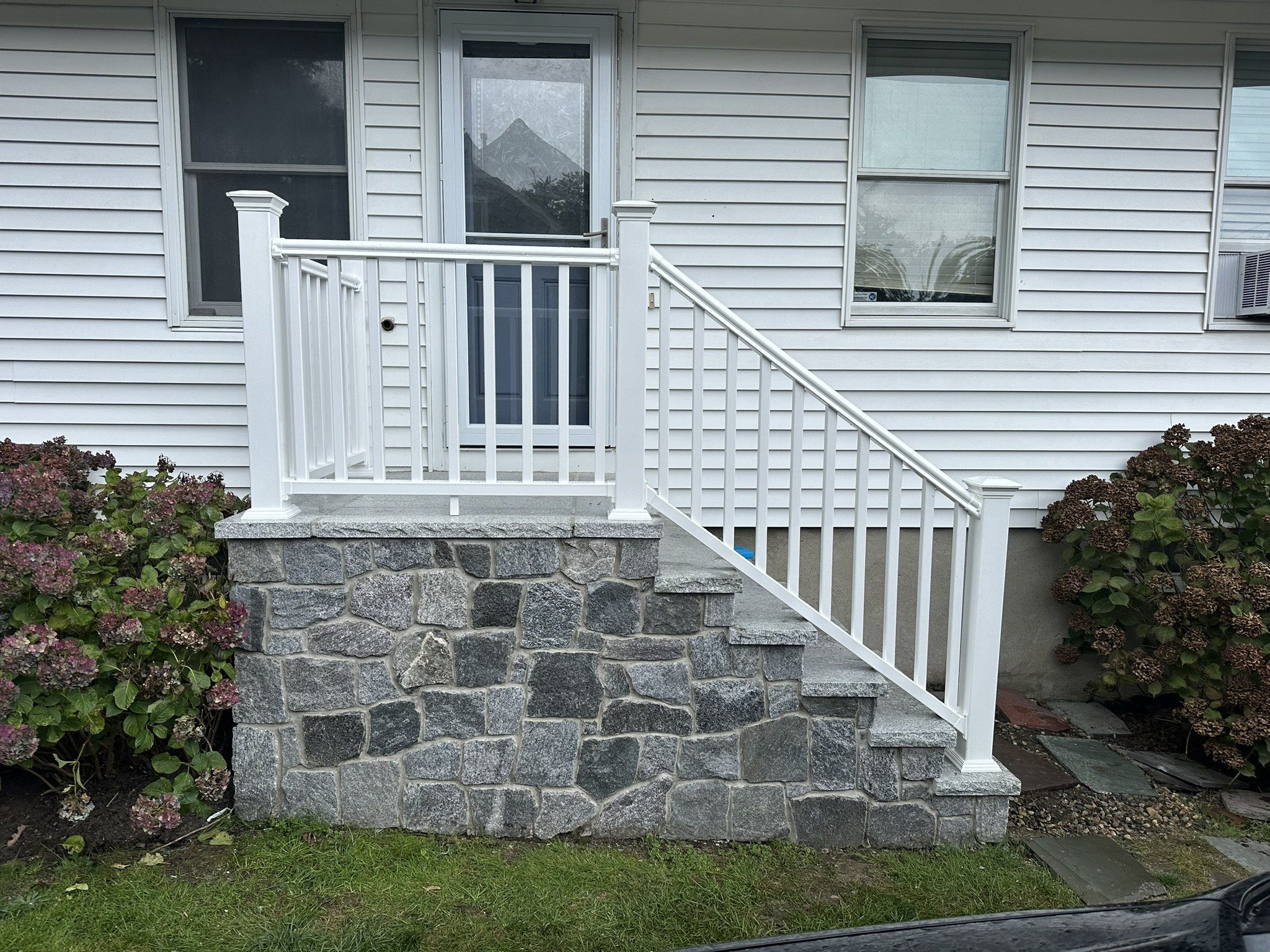 White railing fitted around stone entry steps