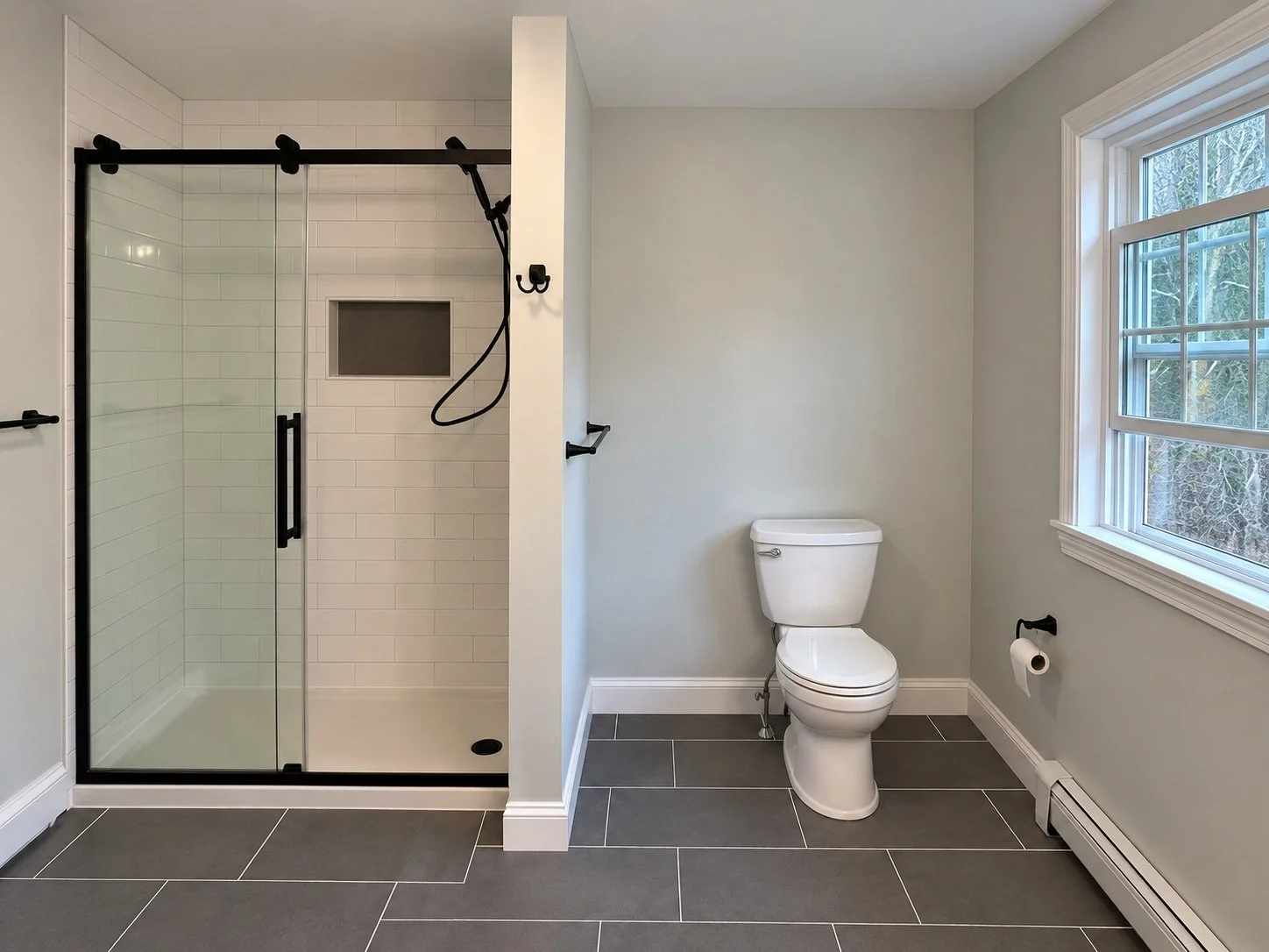 Bathroom with black shower hardware and gray tile floor