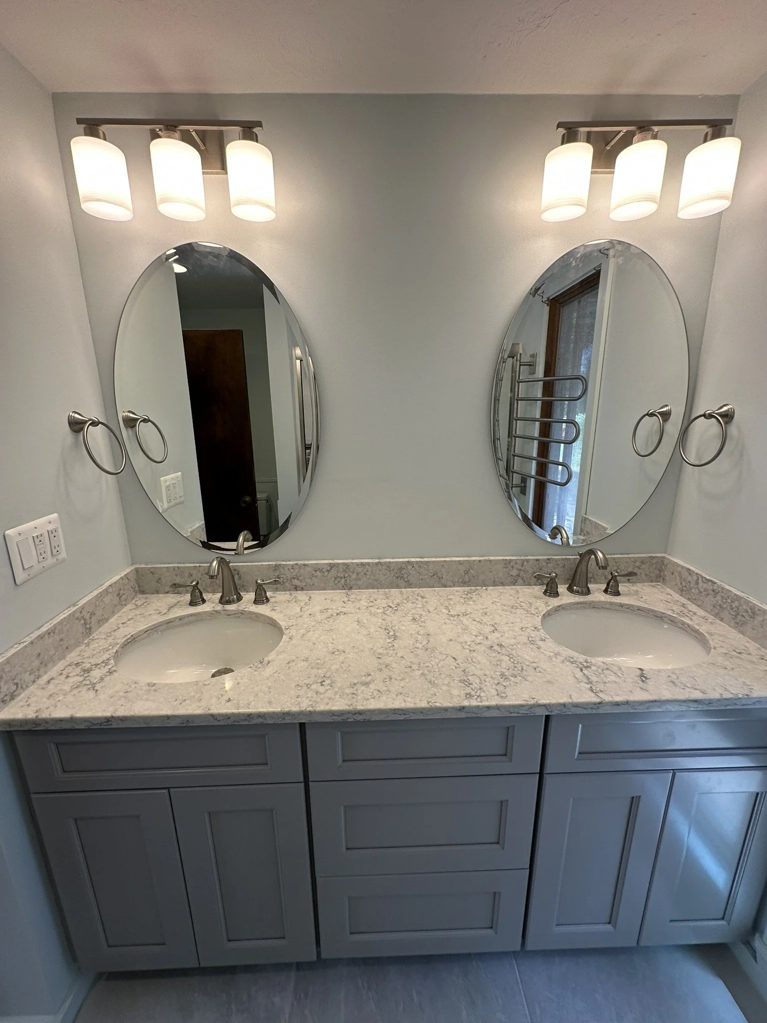 Gray double vanity with oval mirrors