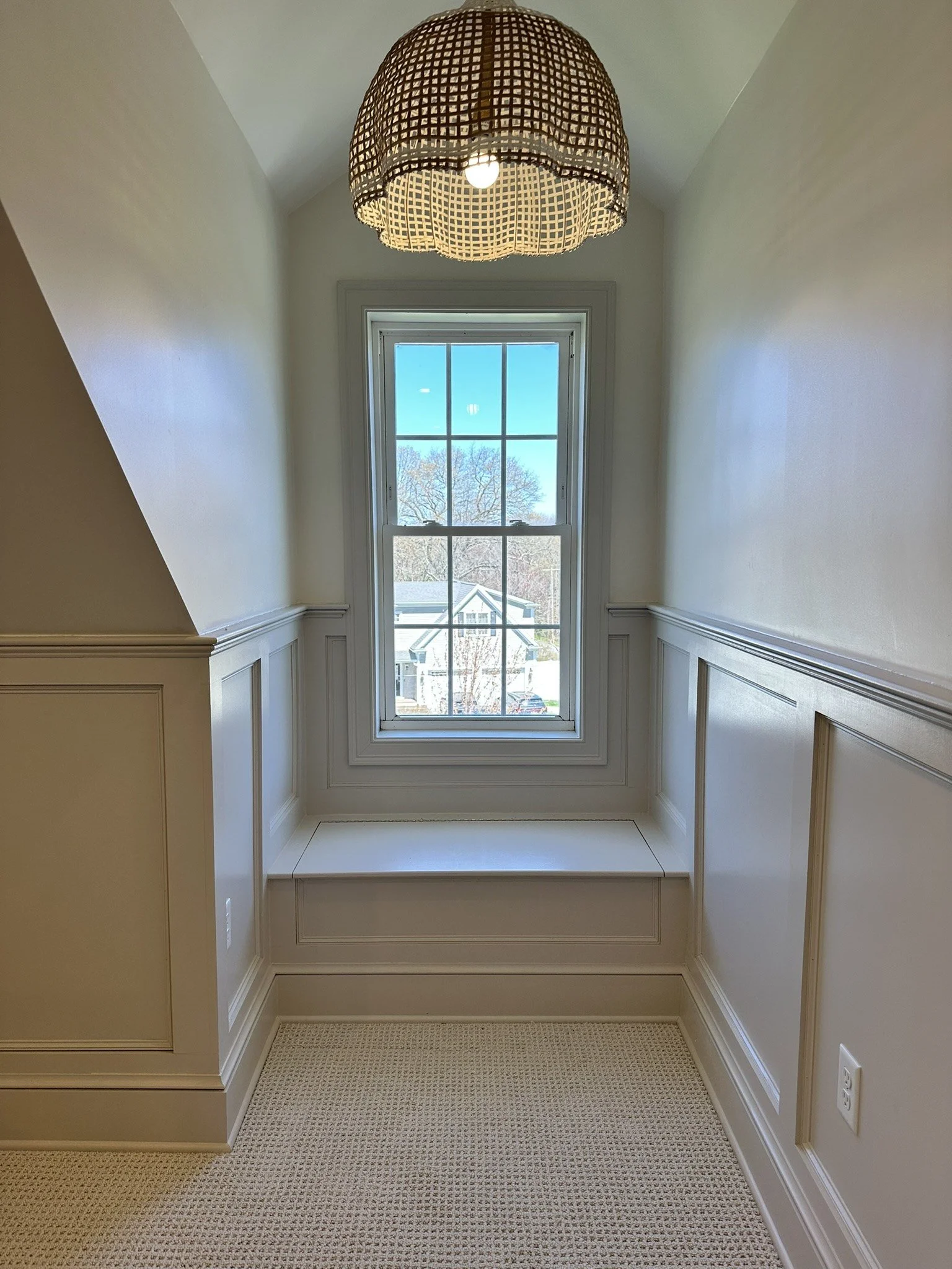Attic window seat and traditional wall wainscoting