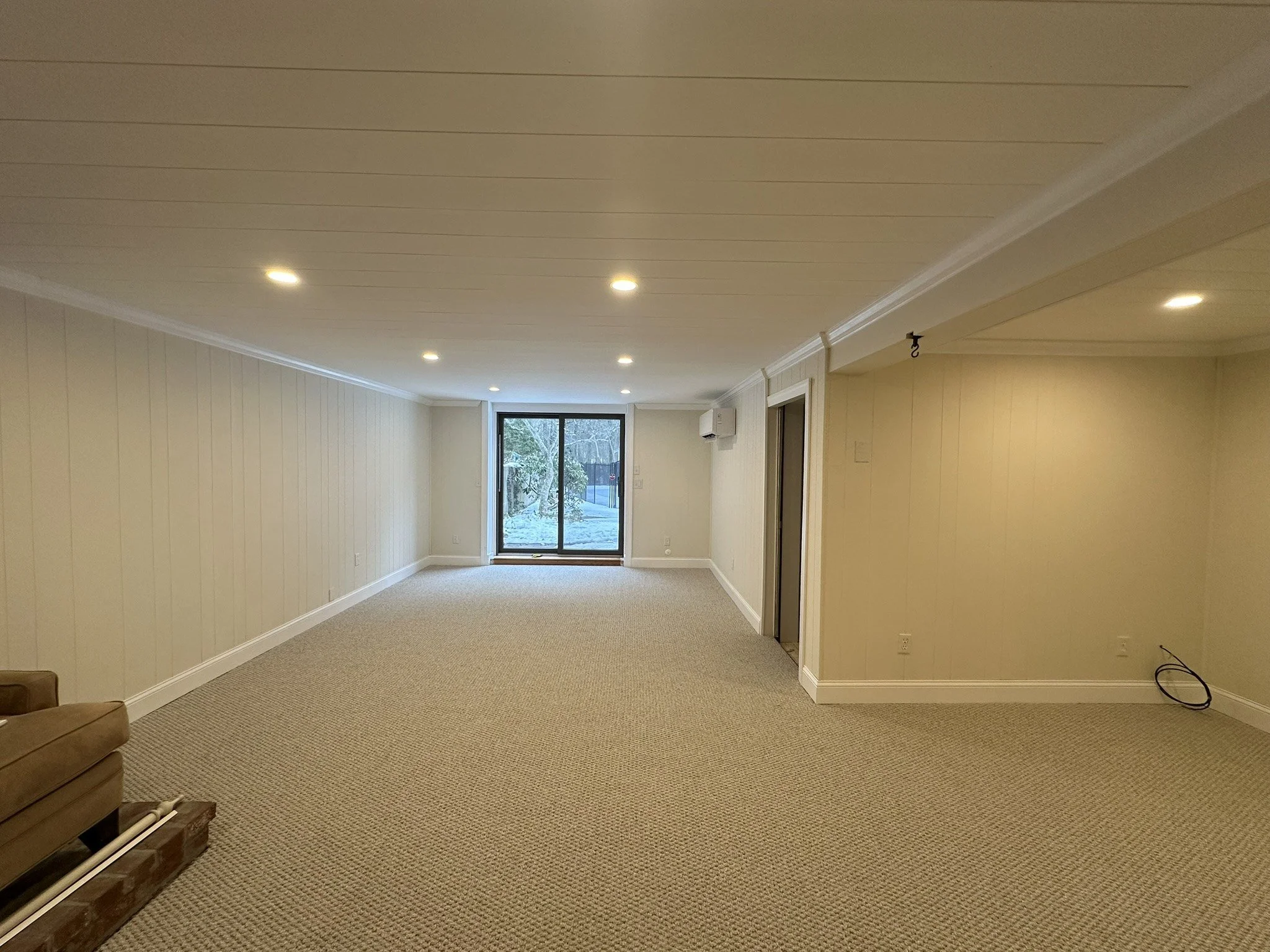 Finished basement family room looking toward sliding door