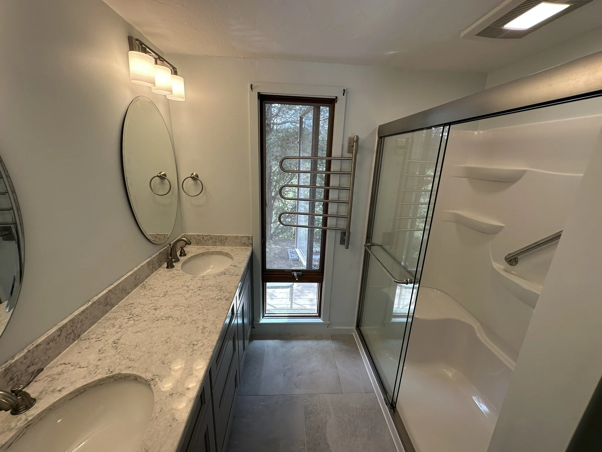 Double vanity and glass shower in a remodeled bathroom