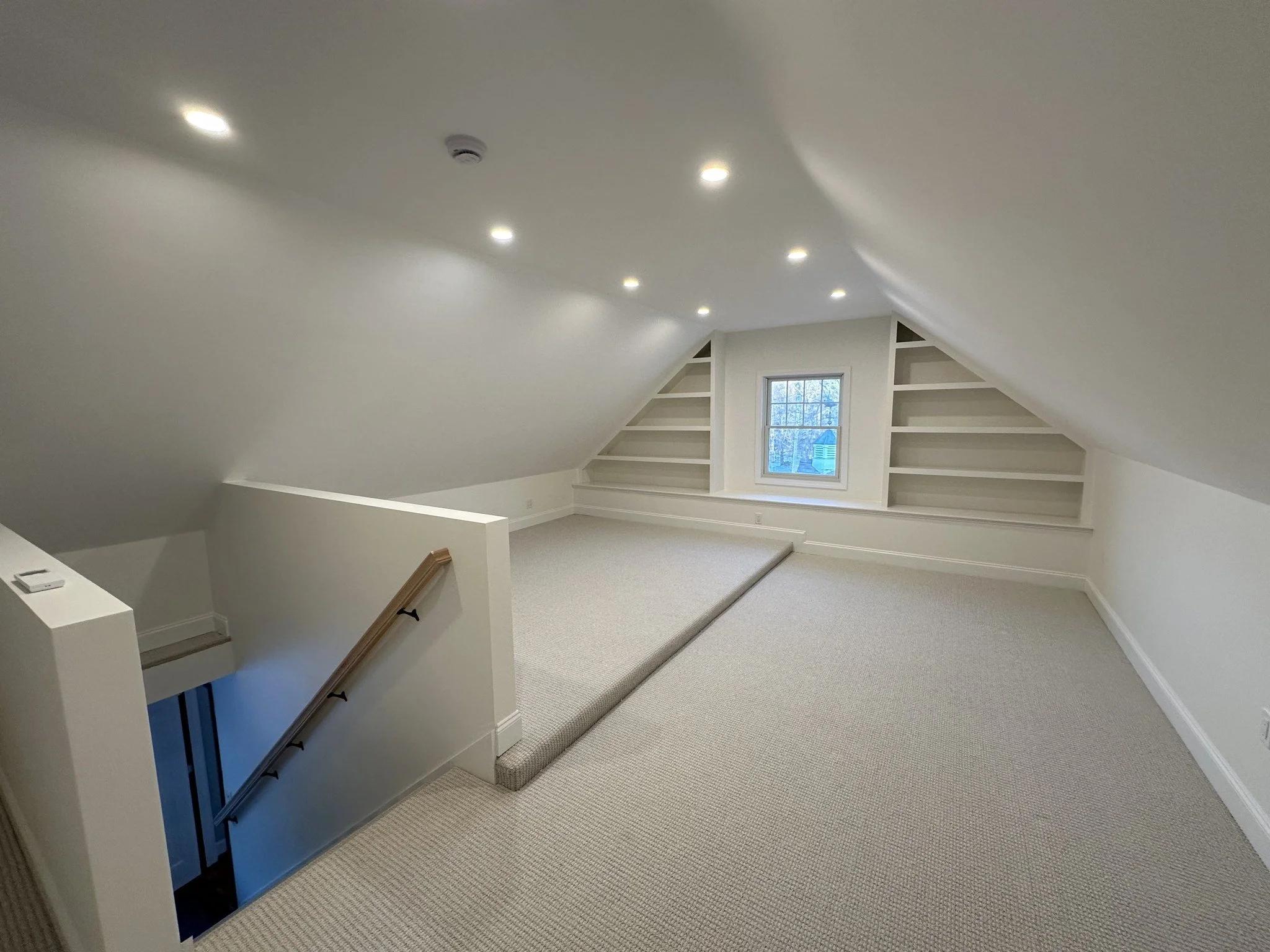 Finished attic with built-in shelves and enclosed stair opening