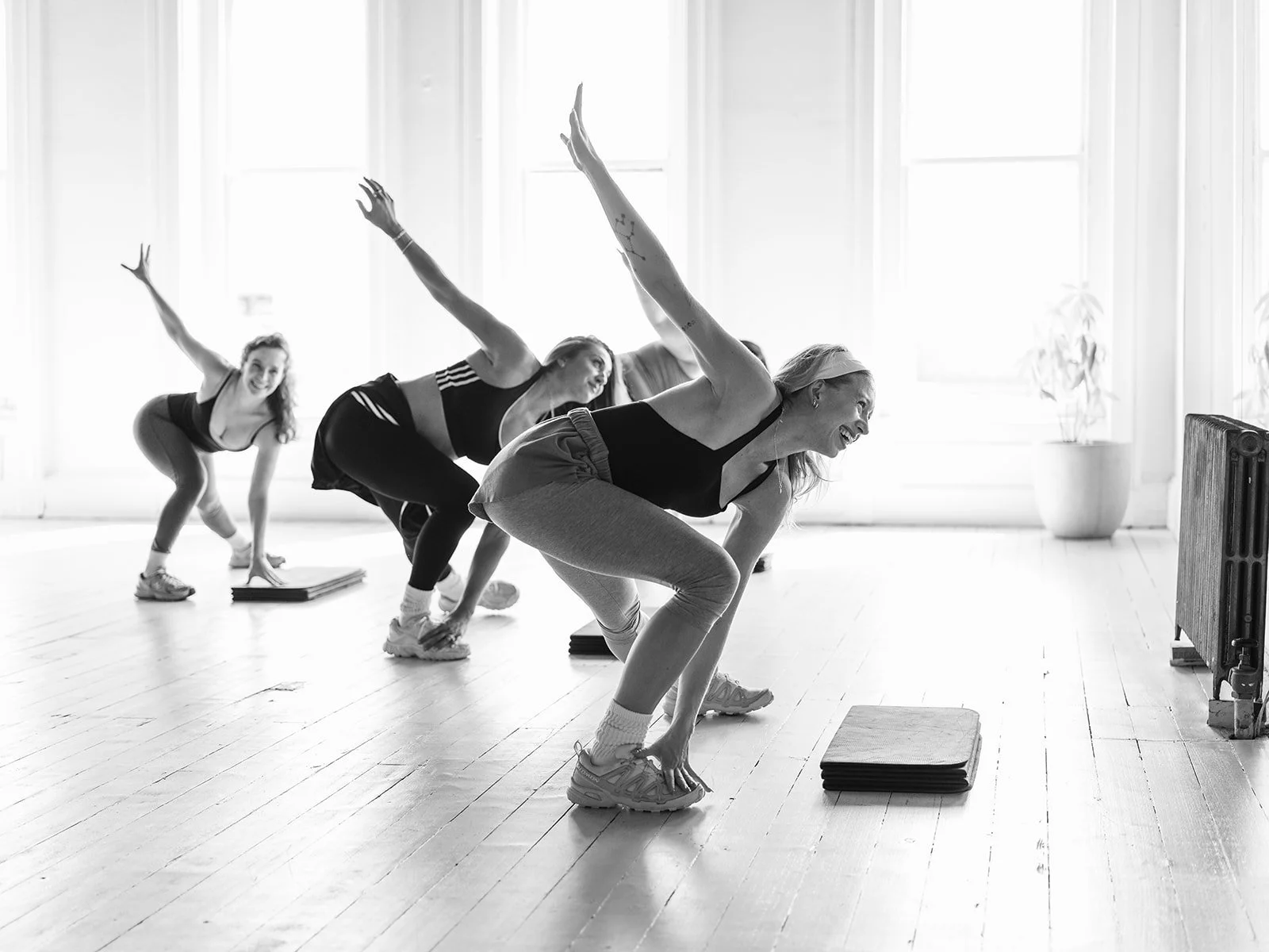 A Margo's class lunging in unison in the sunlit studio