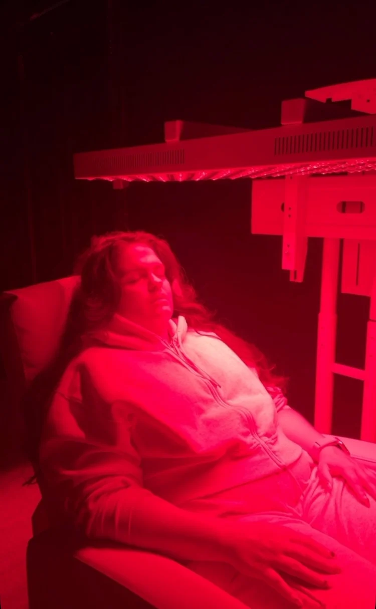 A member relaxing under the red light panels in the recovery room
