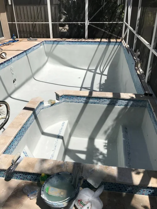 Screened pool and raised spa with the new surface applied during a separate resurfacing project.