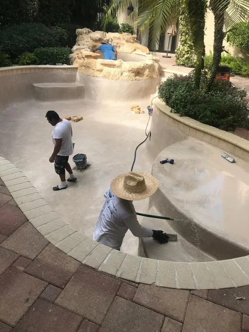 Crew finishing the pool and spa surface during the BallenIsles resurfacing project.