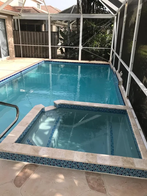 The same screened pool and raised spa refilled after resurfacing.