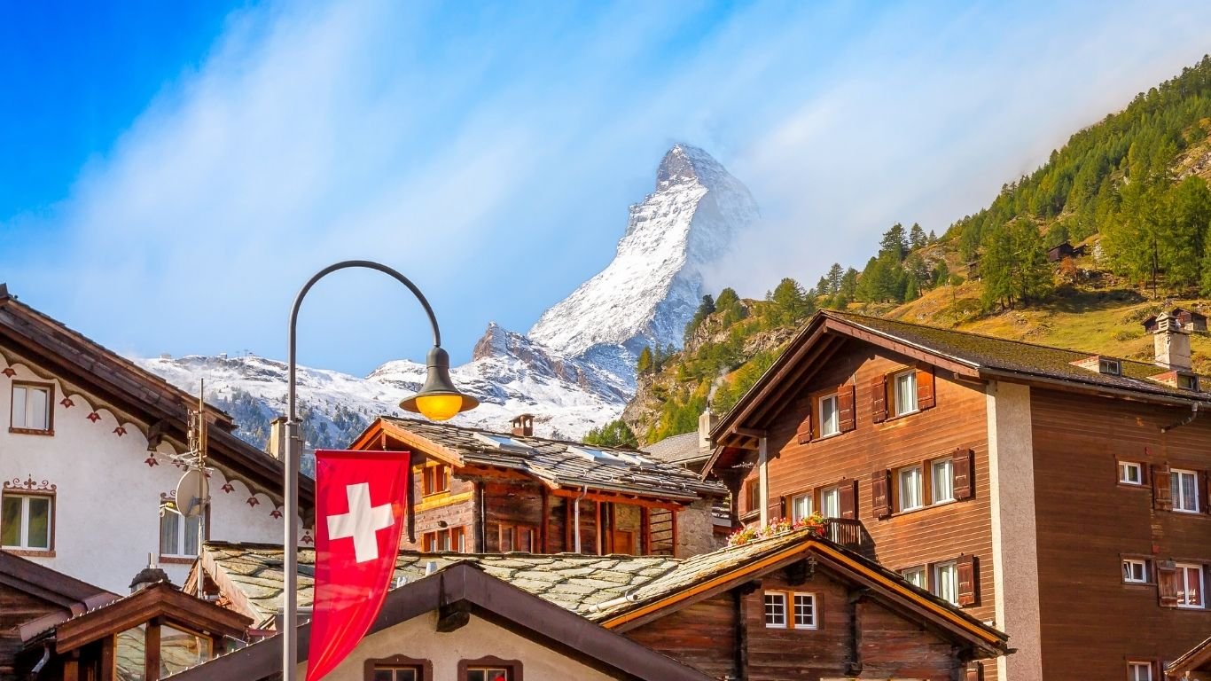 Traditional Swiss chalets with the Matterhorn mountain in the background, showcasing Switzerland’s iconic alpine scenery and architecture.