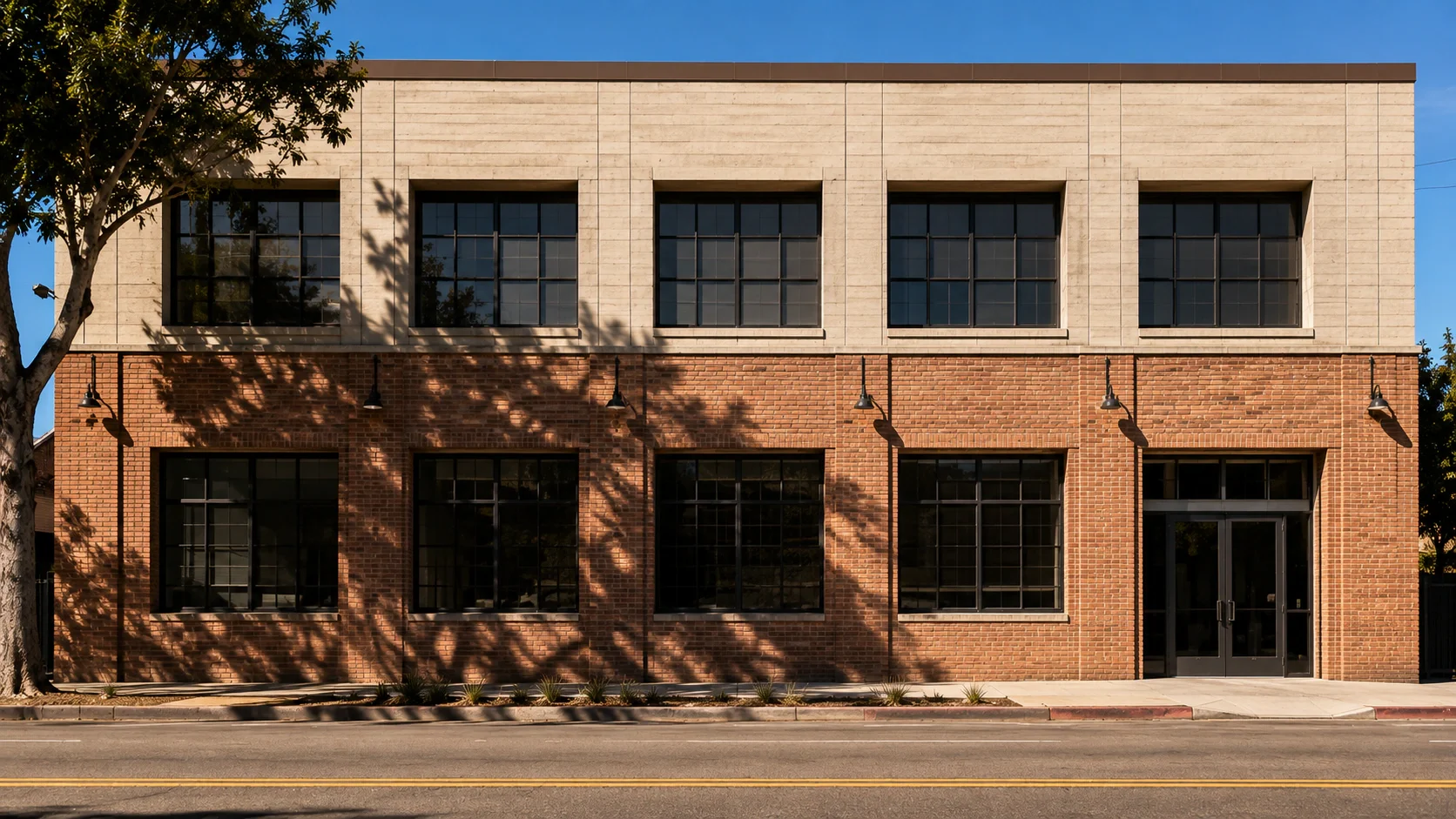 A level, square-on elevation of a two-storey commercial building in brick and board-formed concrete, with a street-tree shadow across the lower facade and every joint, reveal and window frame legible.