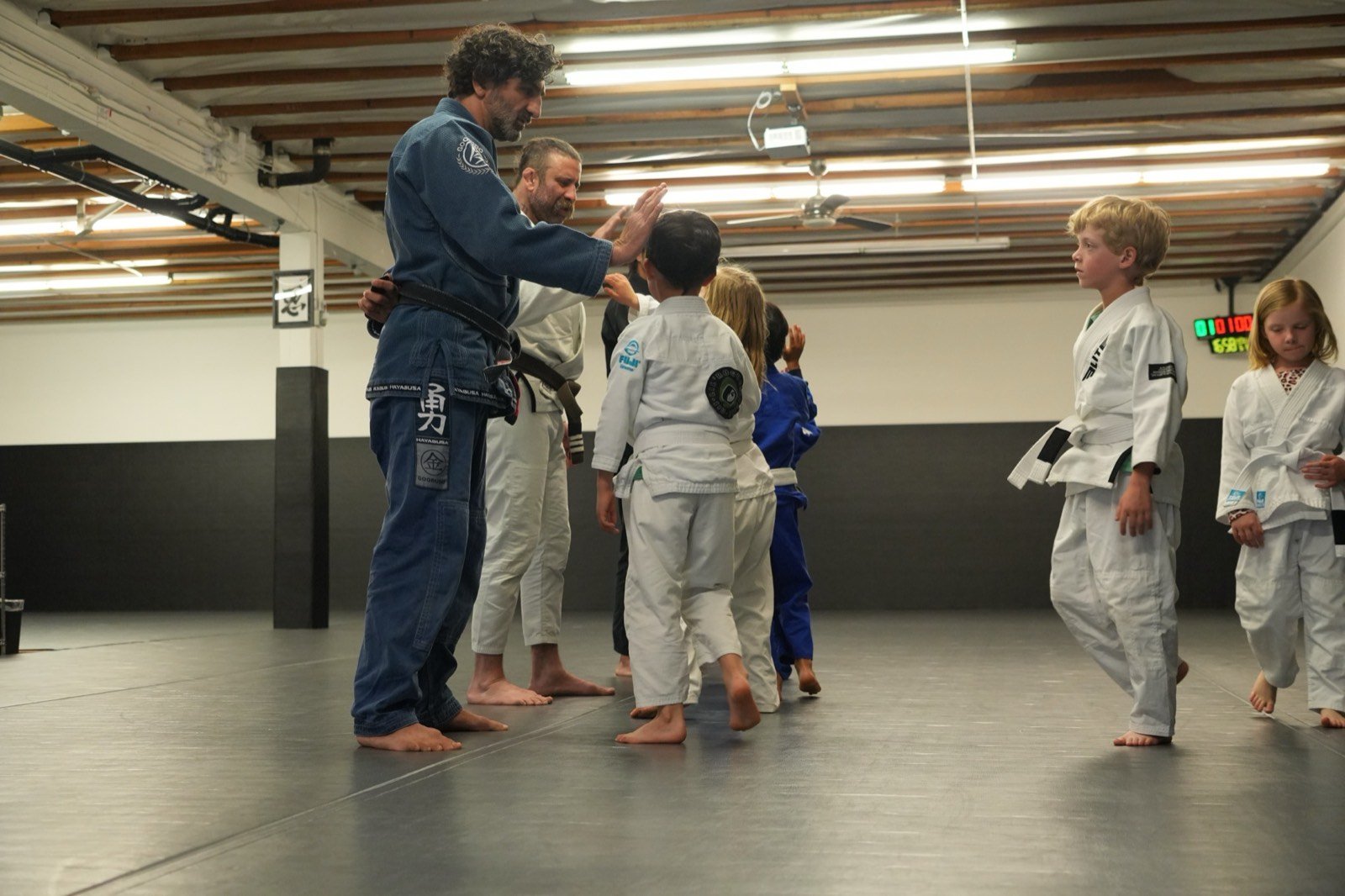 Coaches high-fiving kids at the end of a Lil' Rogues class