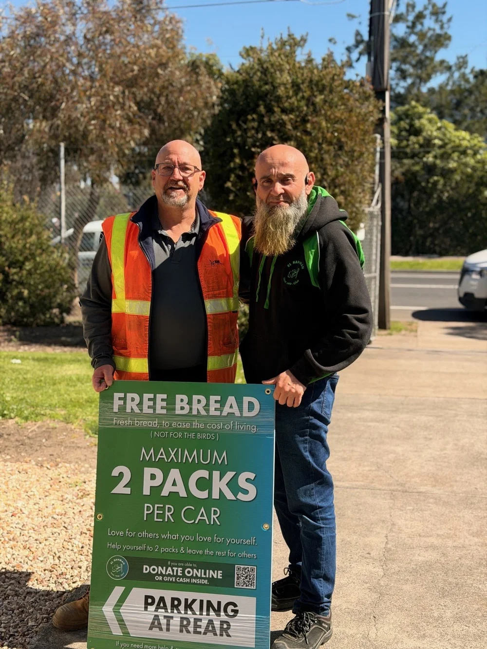 Volunteers beside the El Rahman free bread sign