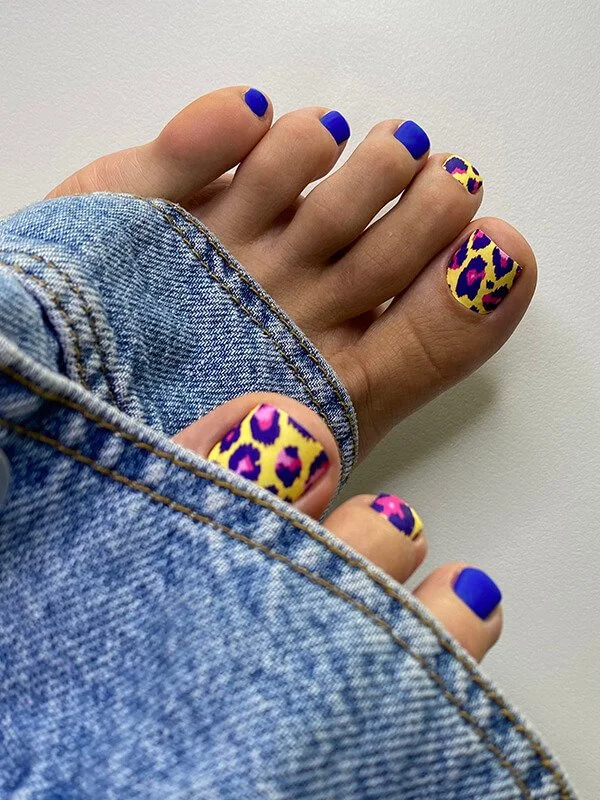 Russian dry pedicure with cobalt blue polish and colorful leopard print nail art