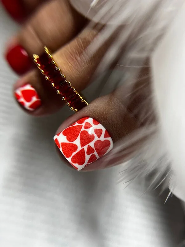 Russian dry gel pedicure with red heart nail art on white polish
