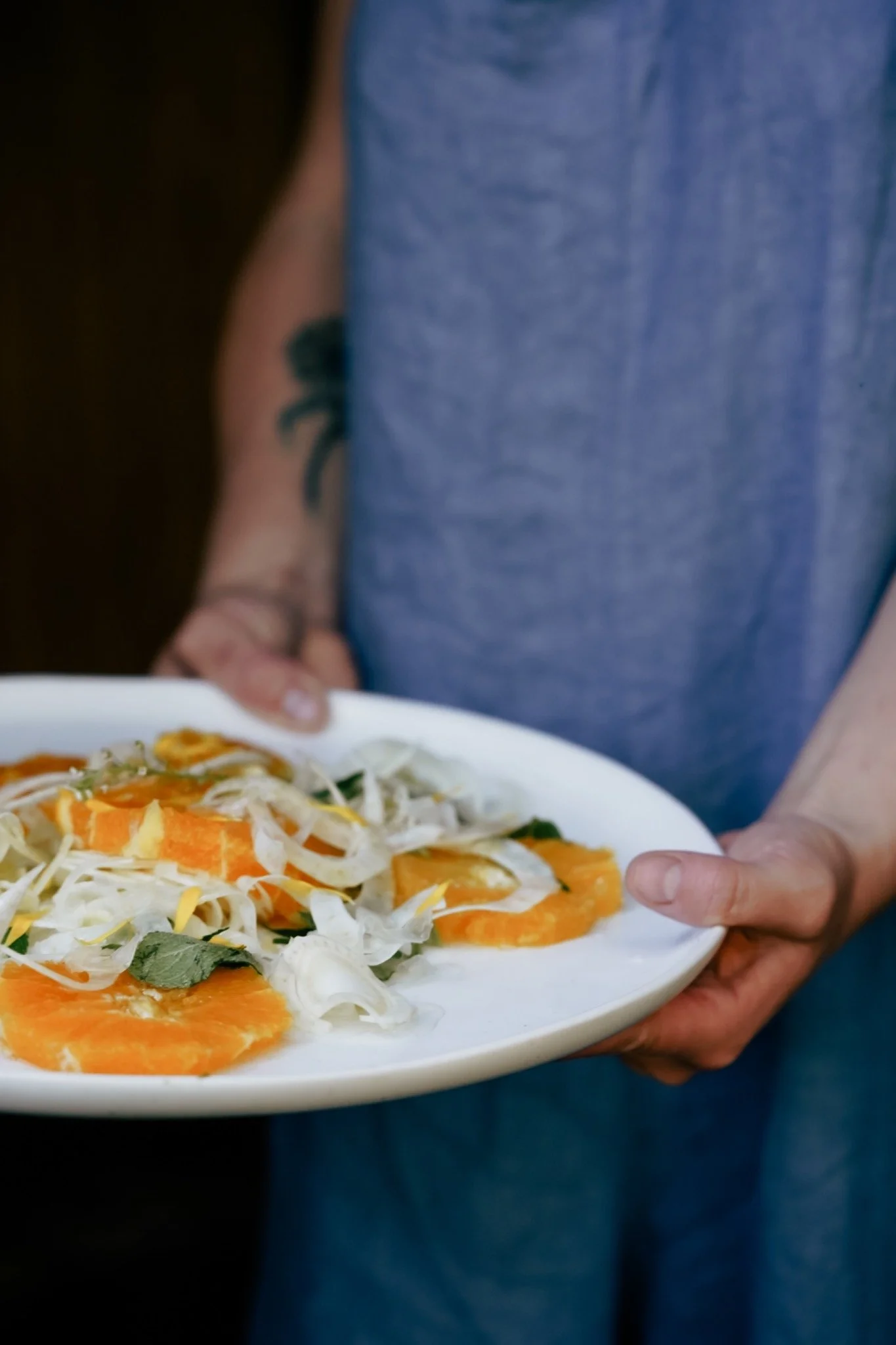 Chef Courtney Jean holding a platter of citrus and shaved fennel