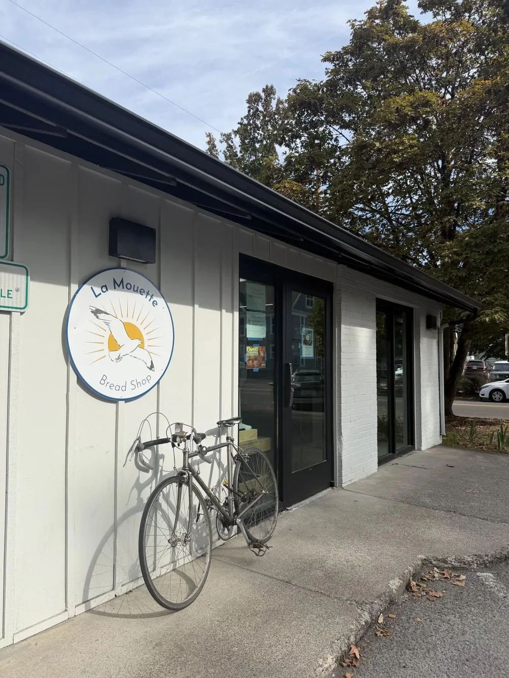 La Mouette storefront with the round seagull sign and a bike out front