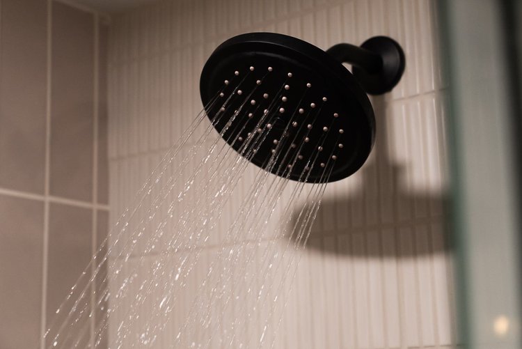 Tiled step-in shower with a matte black rain shower head