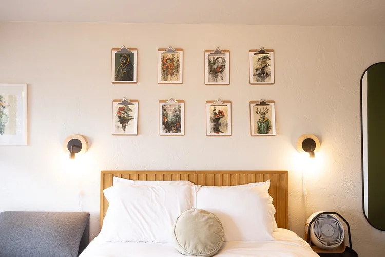 Queen bed with botanical prints in room 201