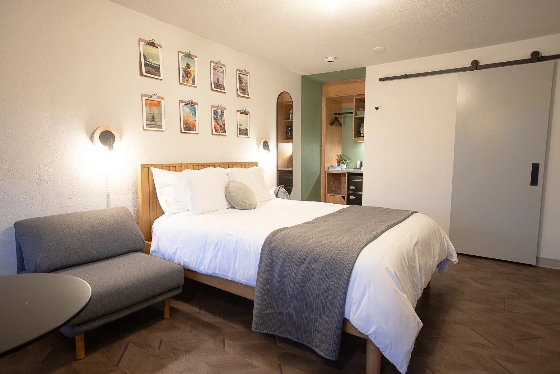 Local Queen room 203 with its art wall, queen bed and sofa