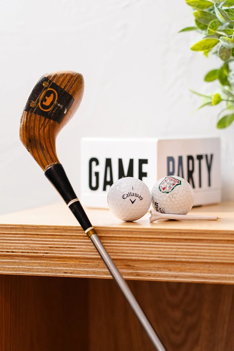 A vintage golf club and game on the shelf