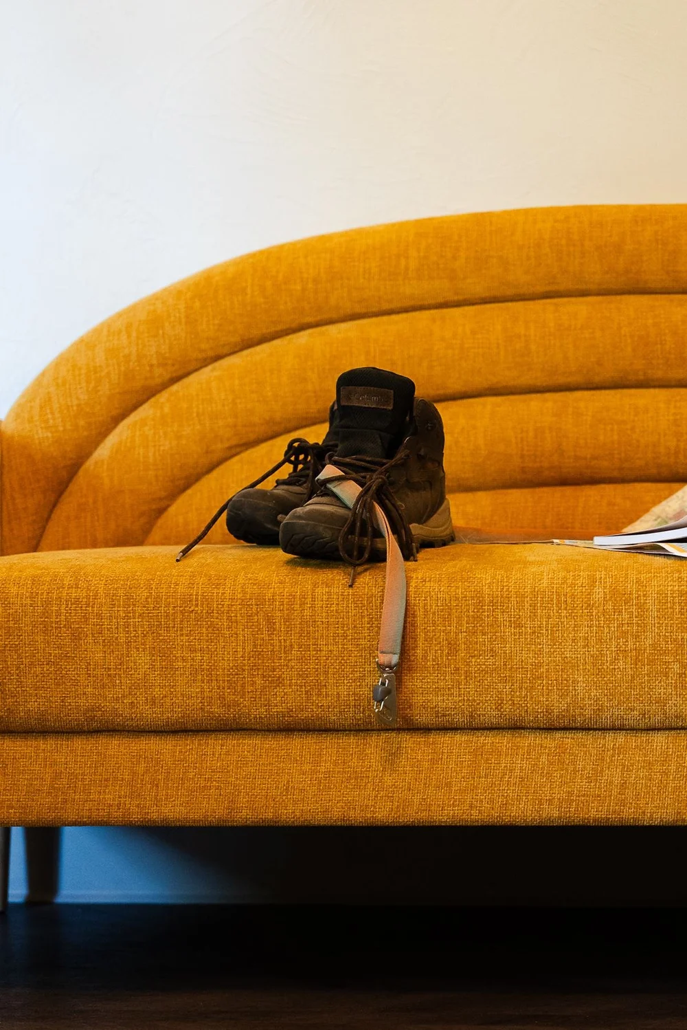 Hiking boots resting on a yellow sofa