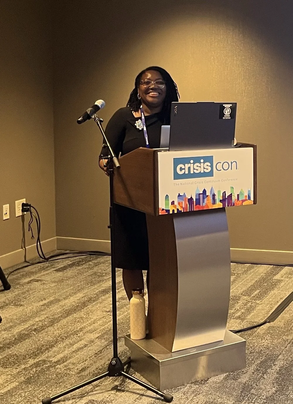 Olivia L. Baylor speaking at the CrisisCon 2026 podium