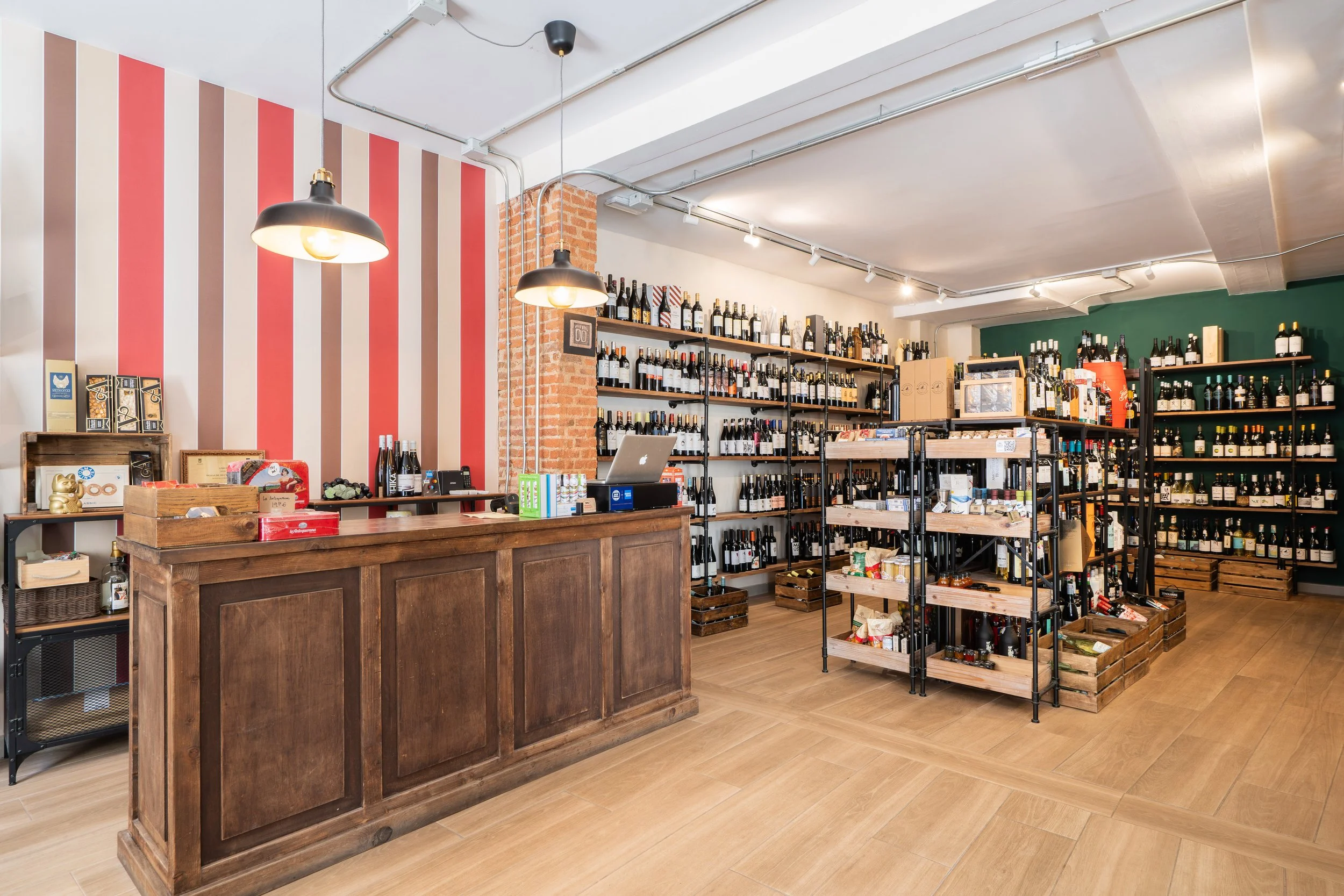 Interior de Madrid & Darracott, con la barra, estanterías de vinos y paredes de rayas