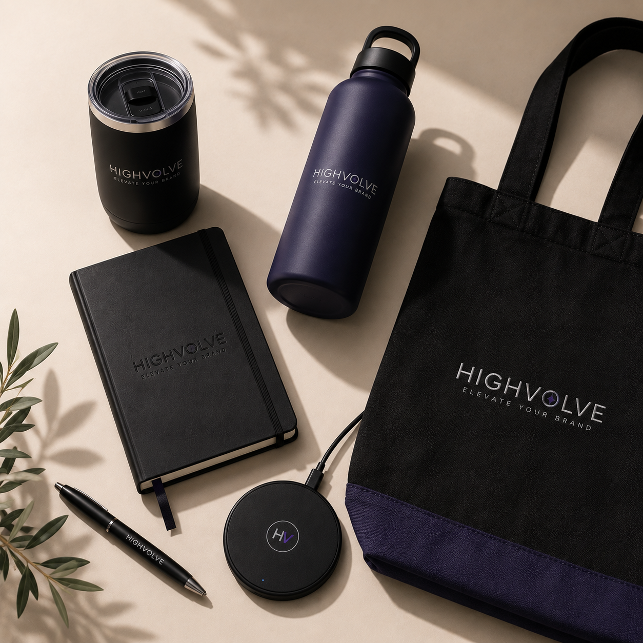 Premium trade show giveaway products including branded drinkware, tote bag, notebook, wireless charger, and executive pen for Las Vegas events.