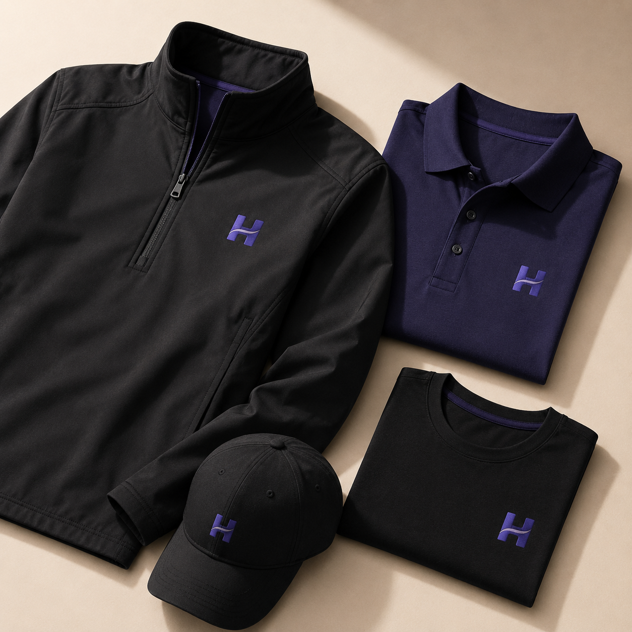 Premium branded trade show apparel including an embroidered quarter-zip jacket, polo shirt, t-shirt, and custom cap arranged in an editorial flat lay.