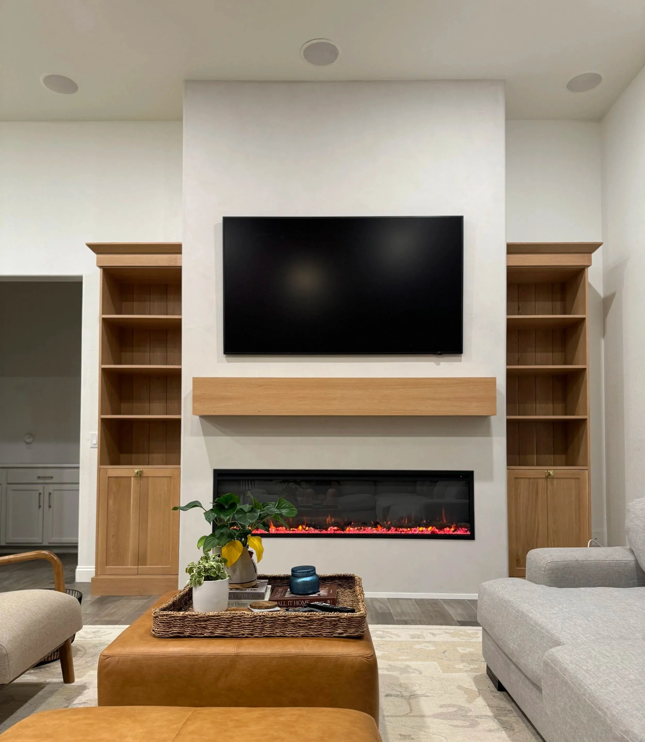 White fireplace wall with a wood mantel and built-in wood cabinets