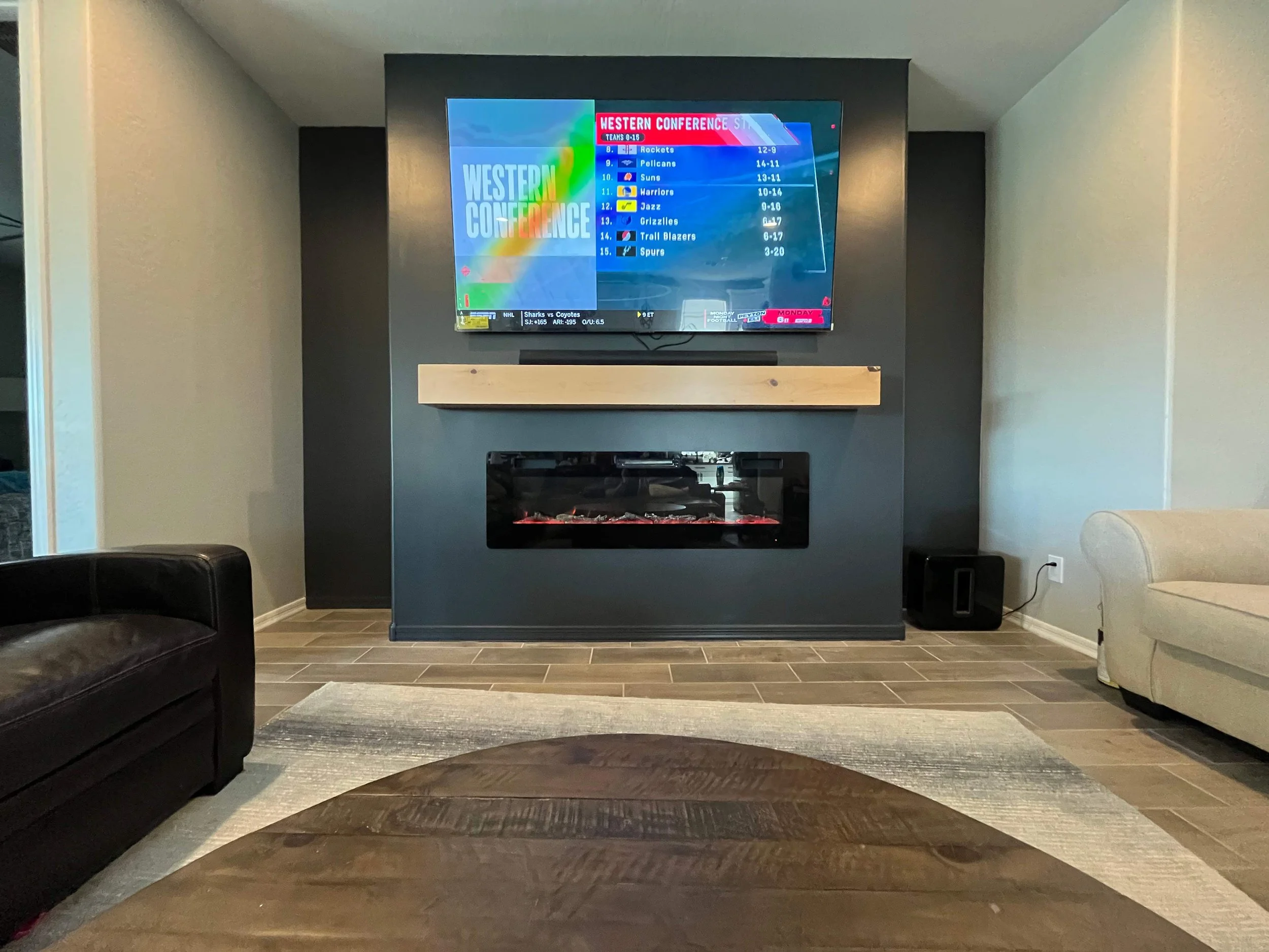 Charcoal fireplace wall with a wood mantel in the finished living room