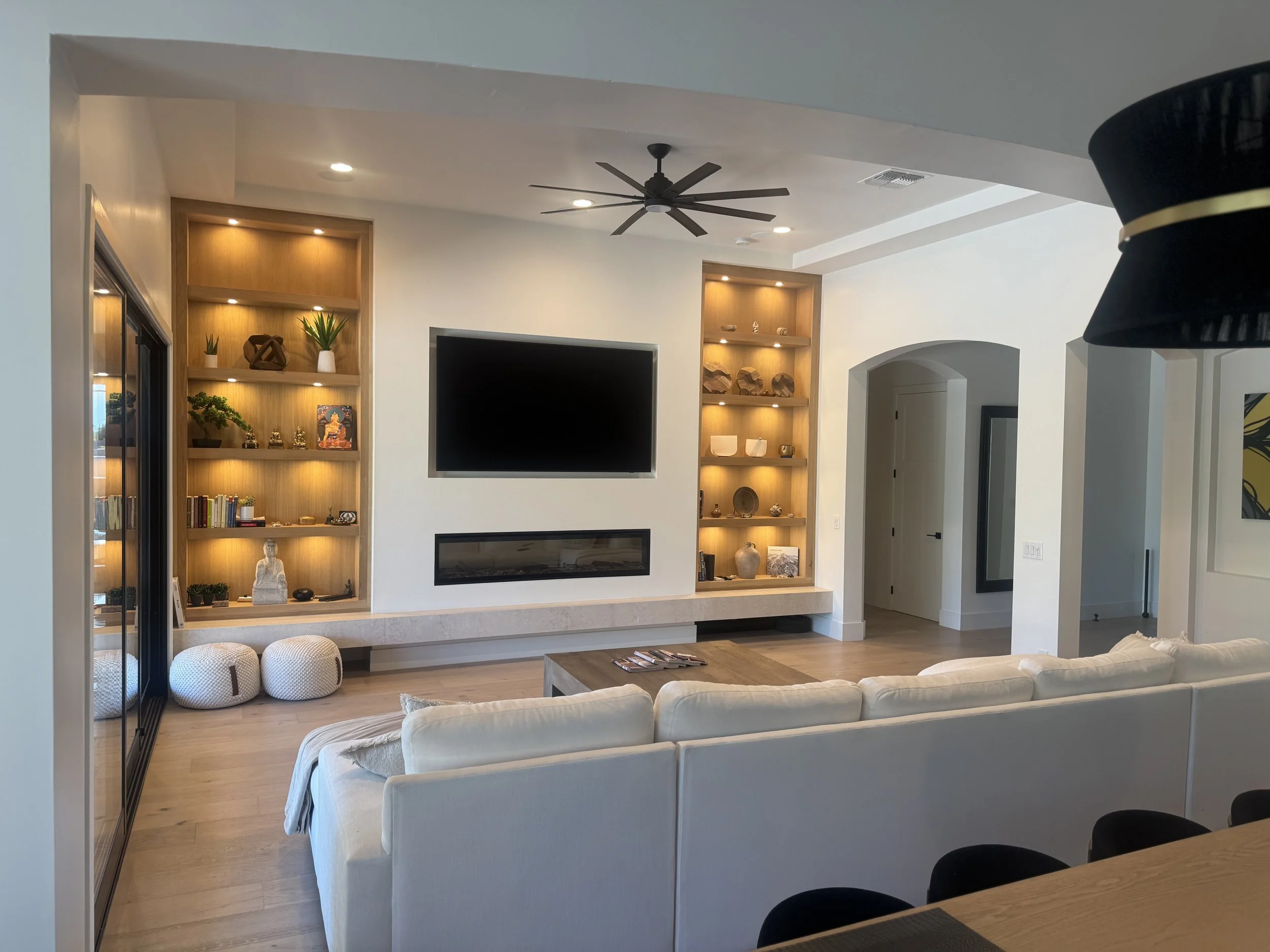 Illuminated wood shelving fireplace, wide living-room view