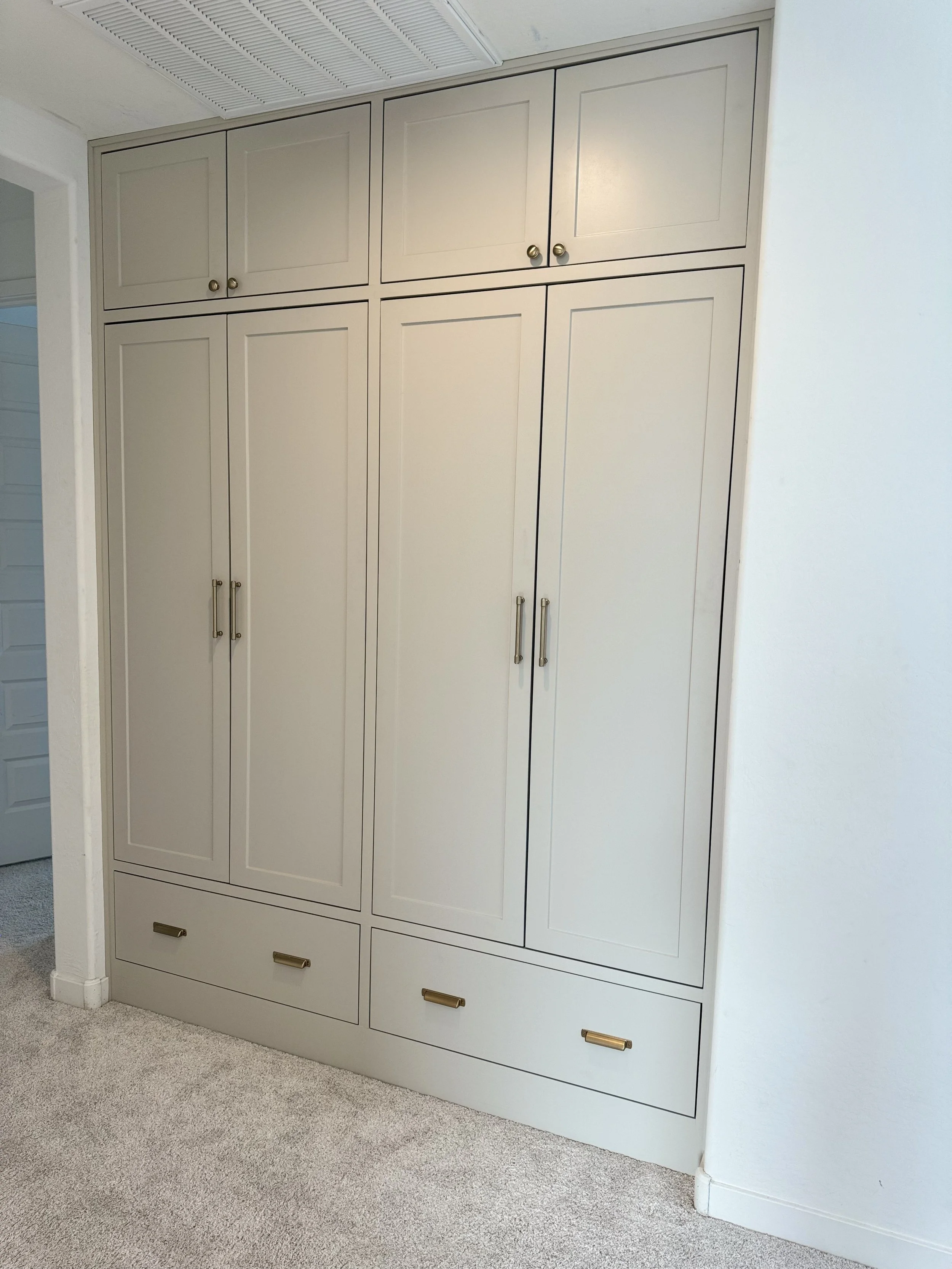 Completed KBK white built-in storage with paneled doors and drawers