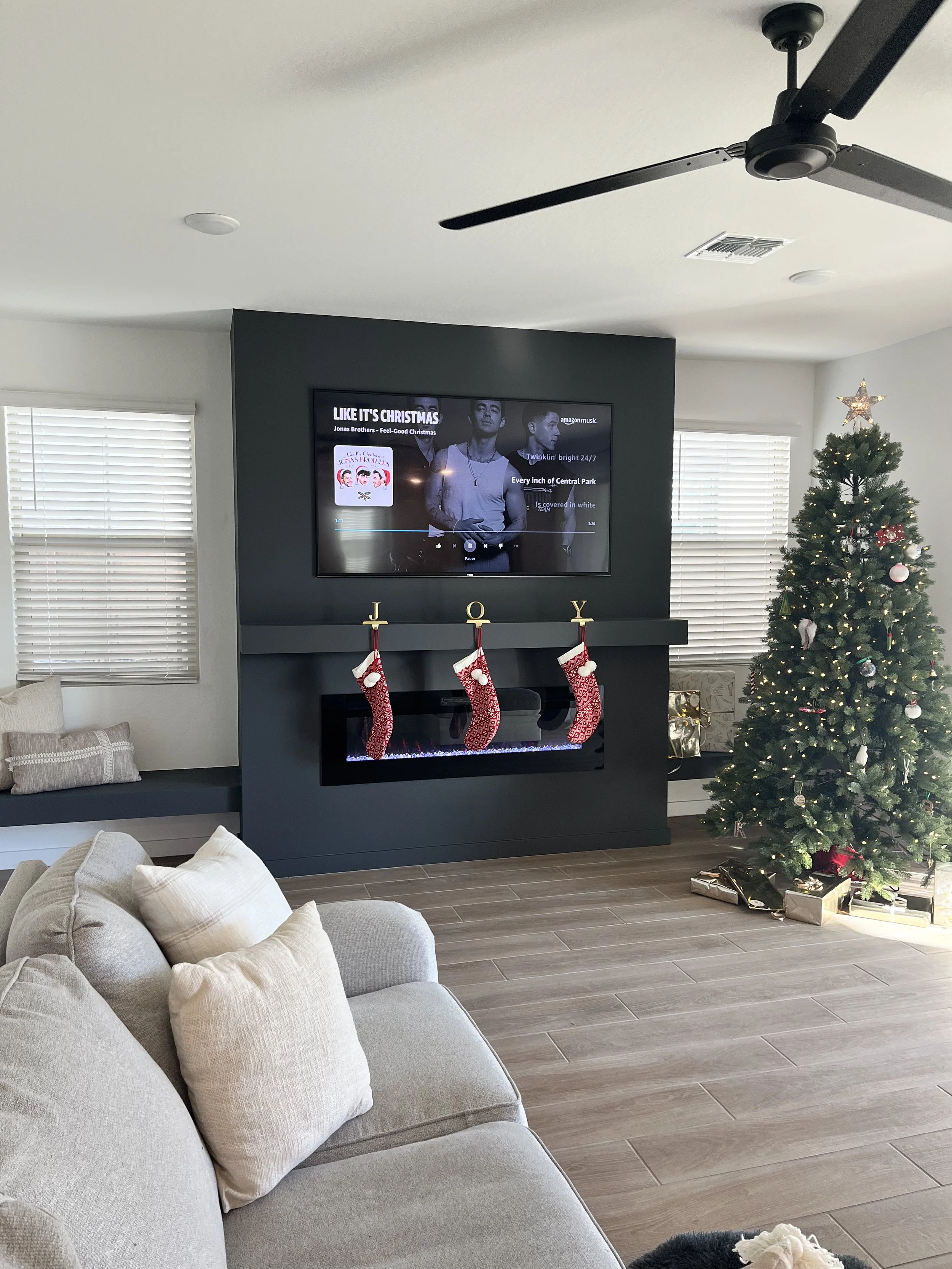Gray fireplace wall and window benches decorated for the holidays