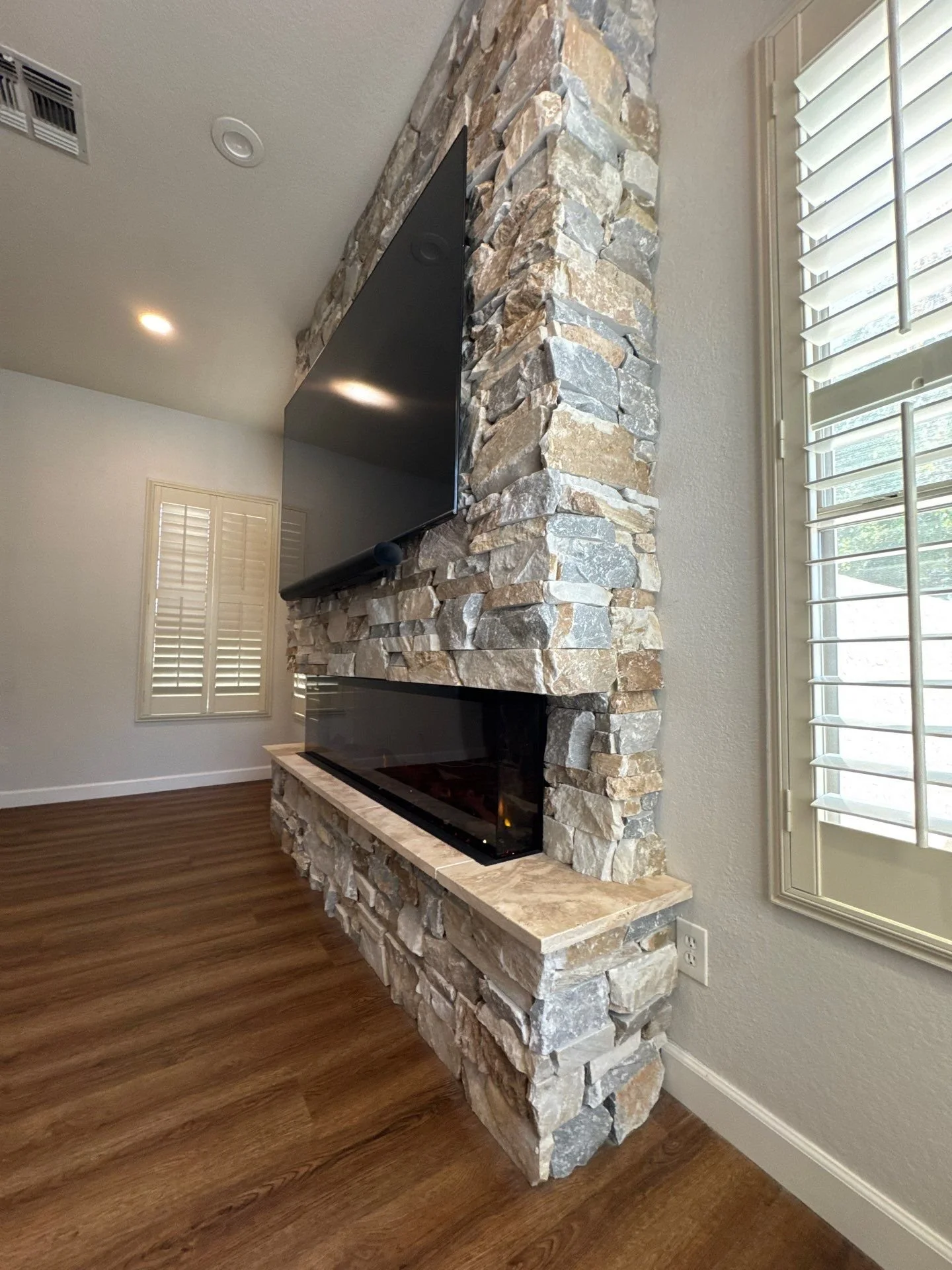 KBK multitone stone fireplace wall and raised hearth
