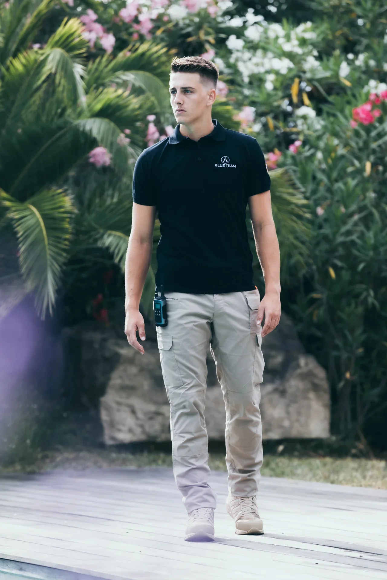 A BLUE TEAM member walking through landscaped residential grounds.