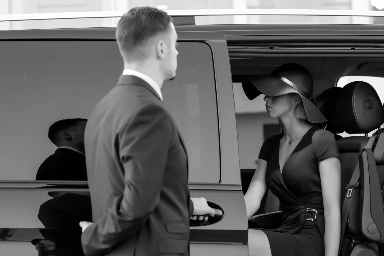 Un chauffeur accueille une passagère à bord d’un van.