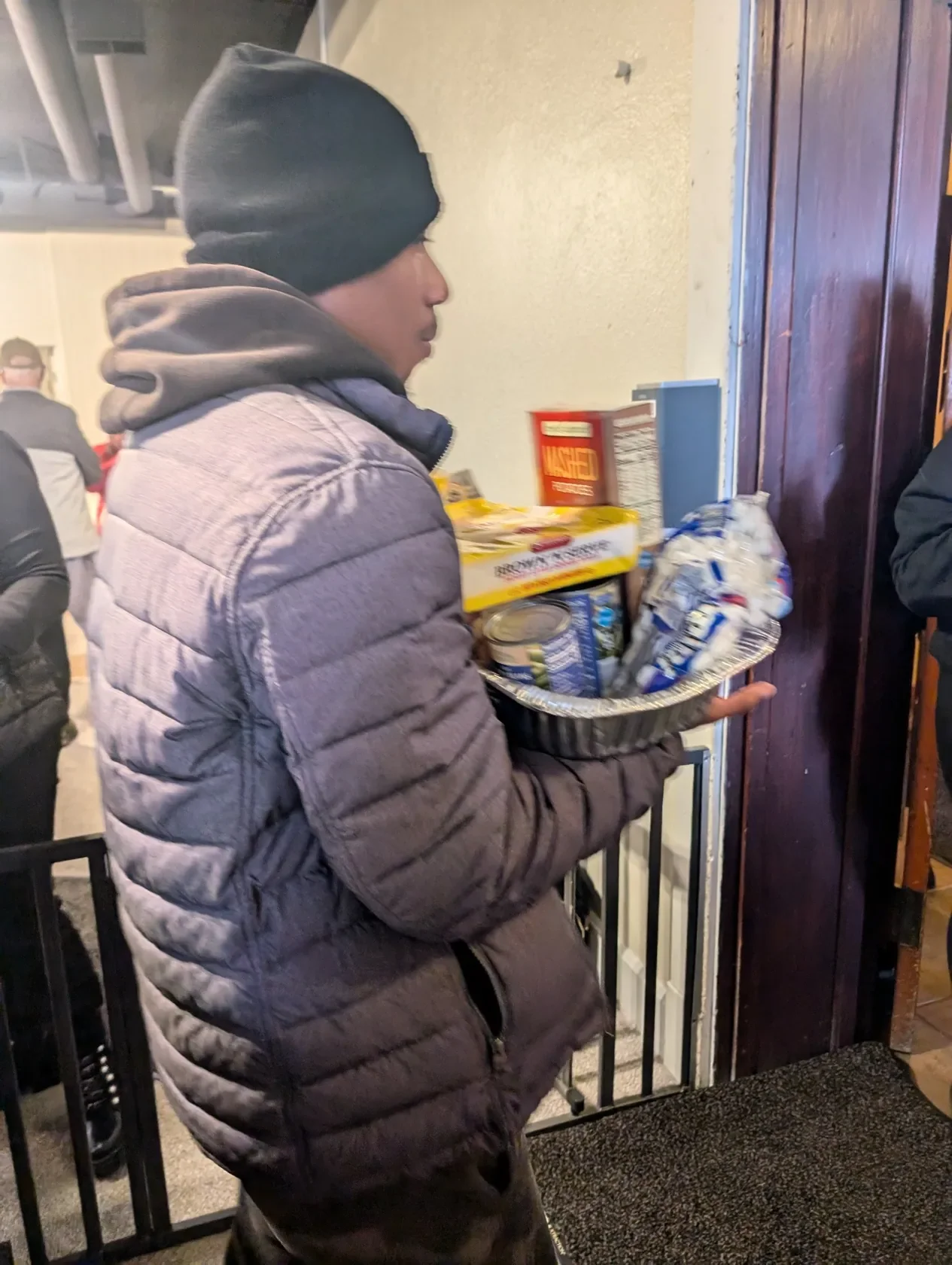 A neighbor carrying home food assistance