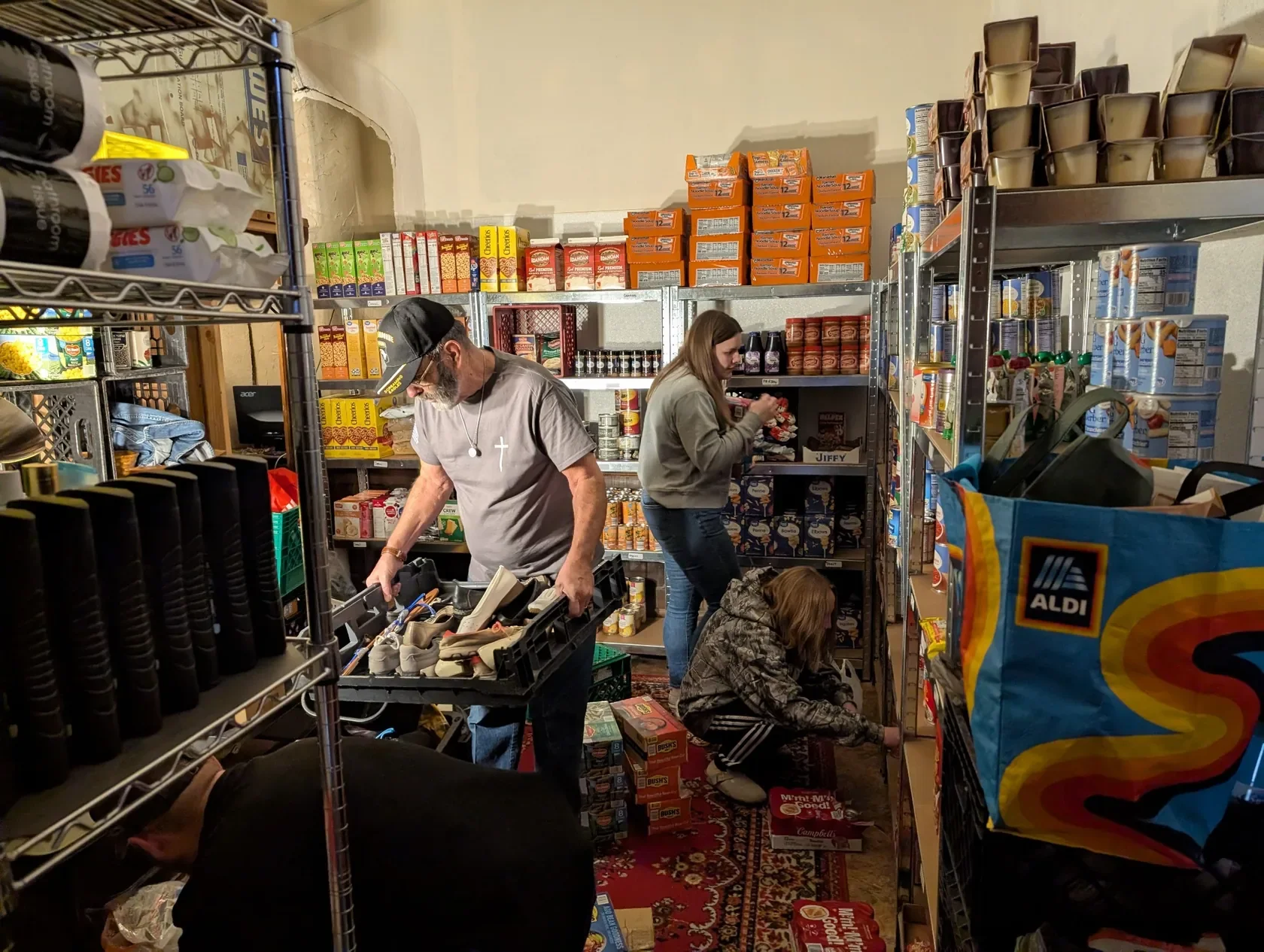 Volunteers checking and organizing food pantry shelves