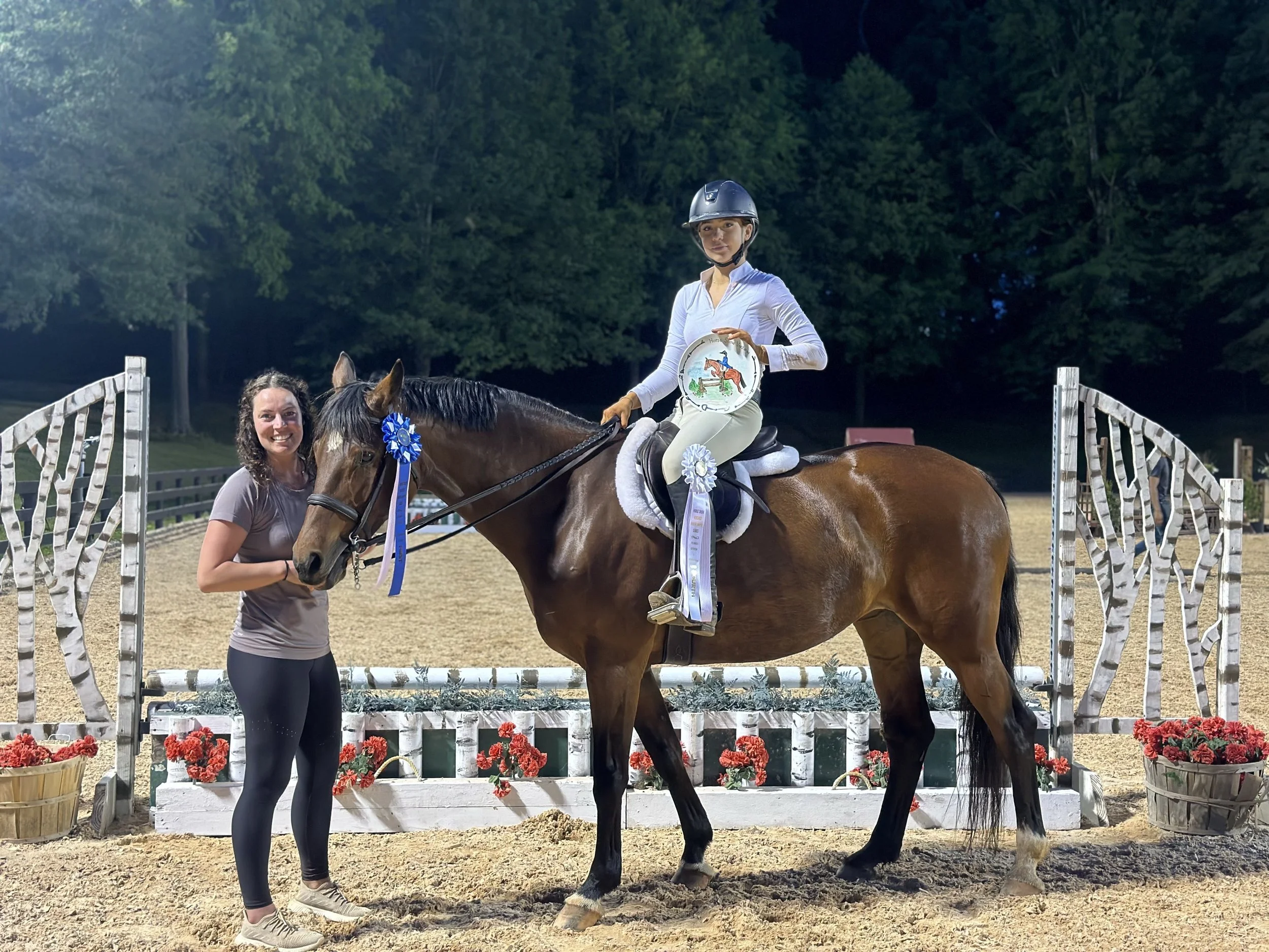 Blackrock rider and trainer celebrating with a horse and show ribbons