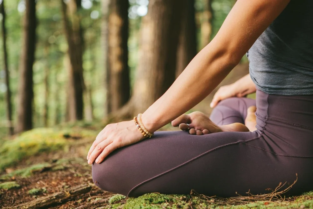 Hand resting on knee in a seated pose