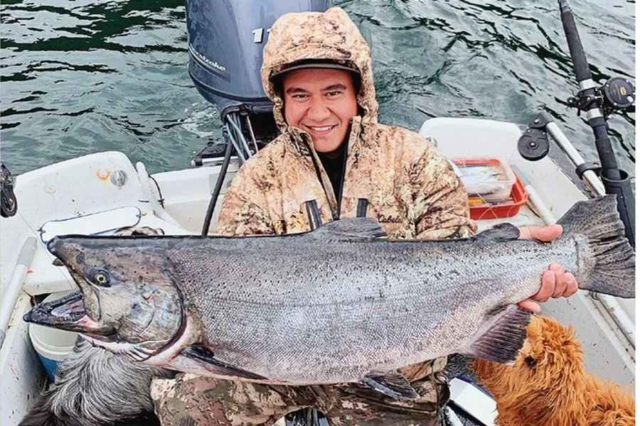 Captain Jameszon Doggett with a king salmon aboard his boat