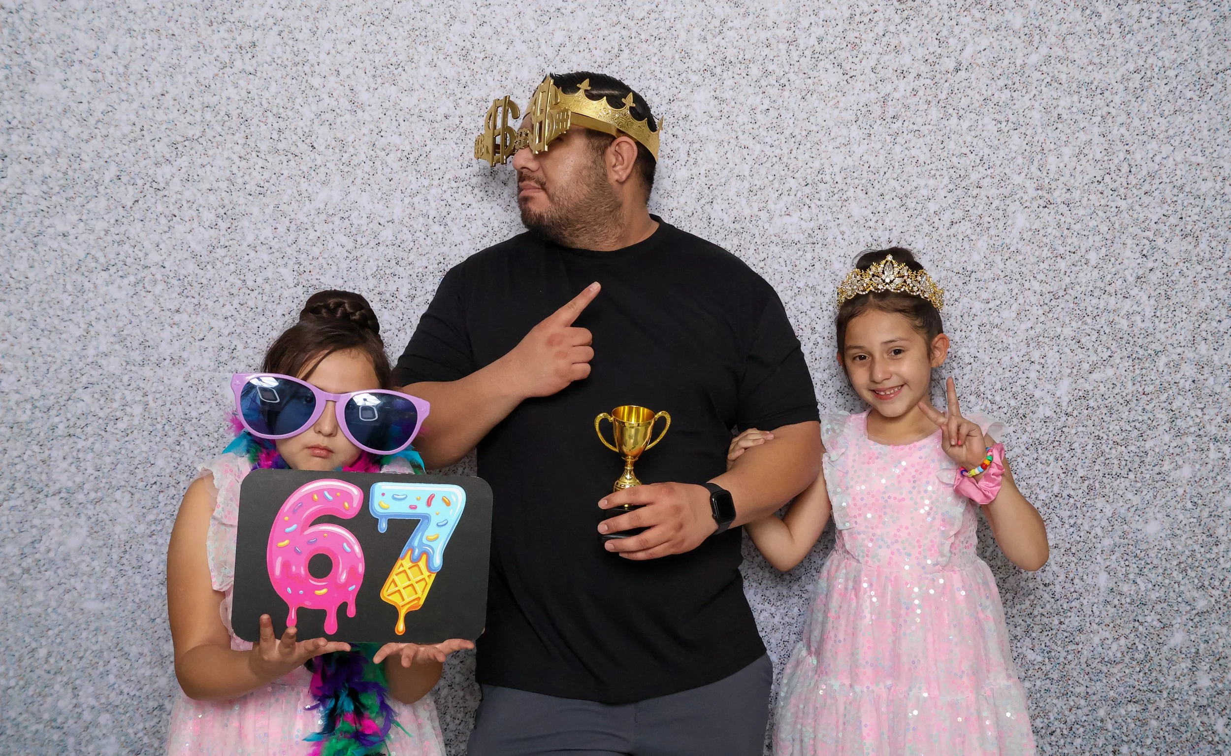 Family posing with oversized glasses, crowns, and custom photo booth props
