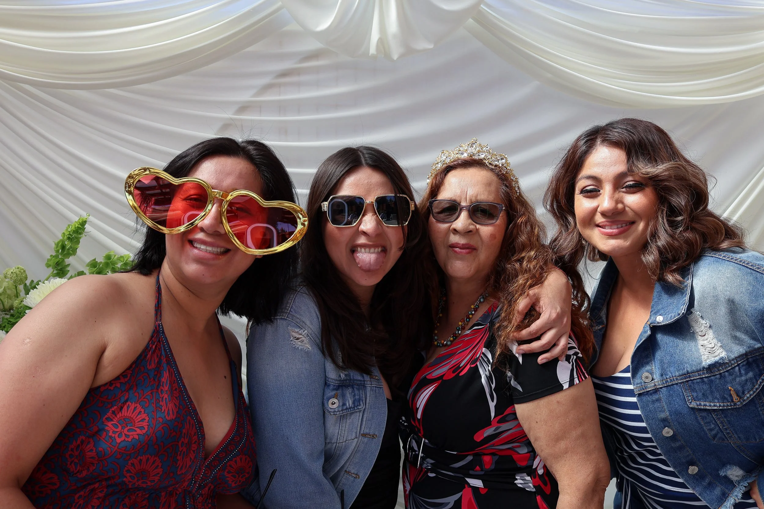 Four guests wearing playful glasses at a private celebration