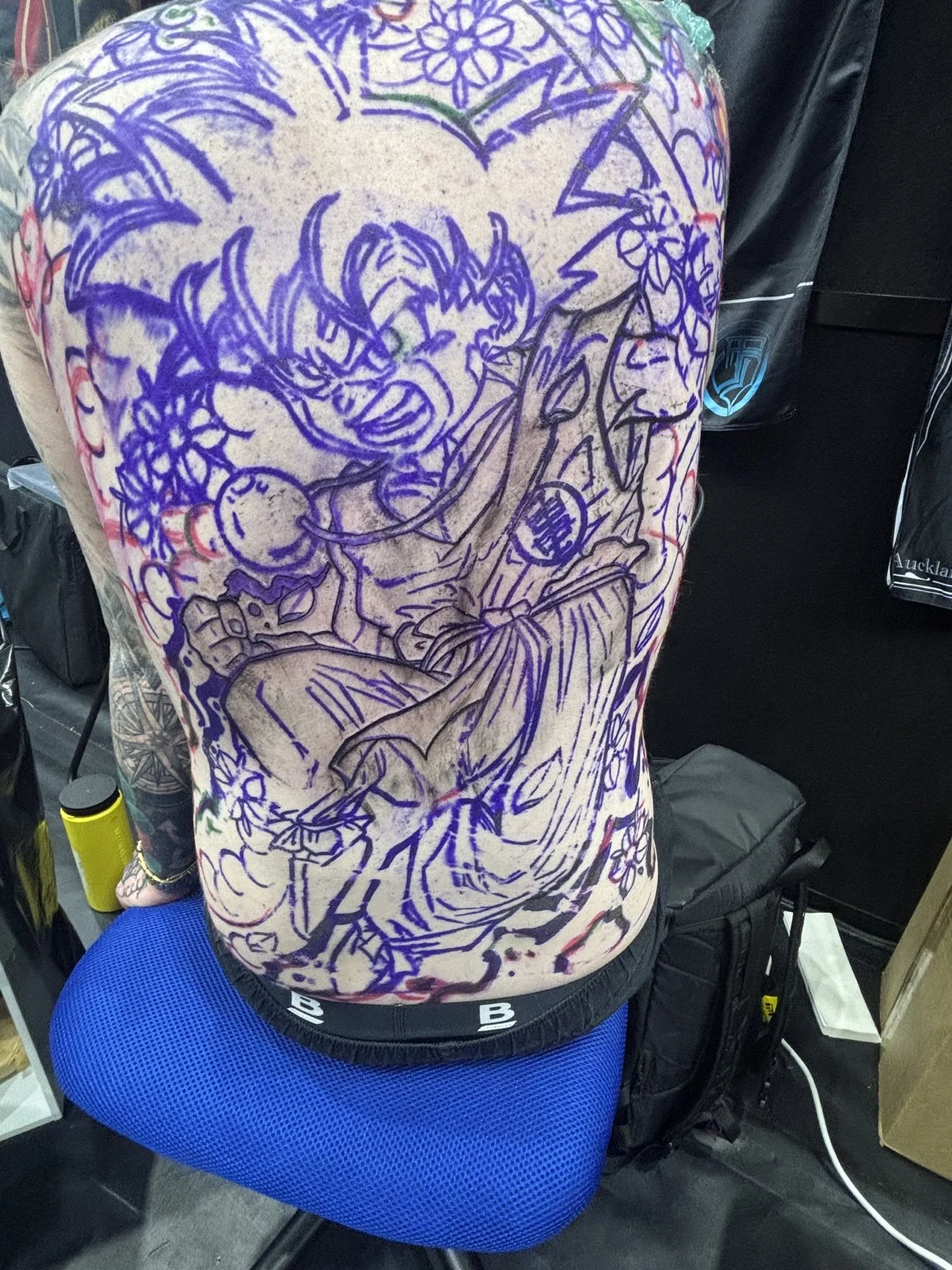 Purple Kid Goku stencil applied across Levi’s back