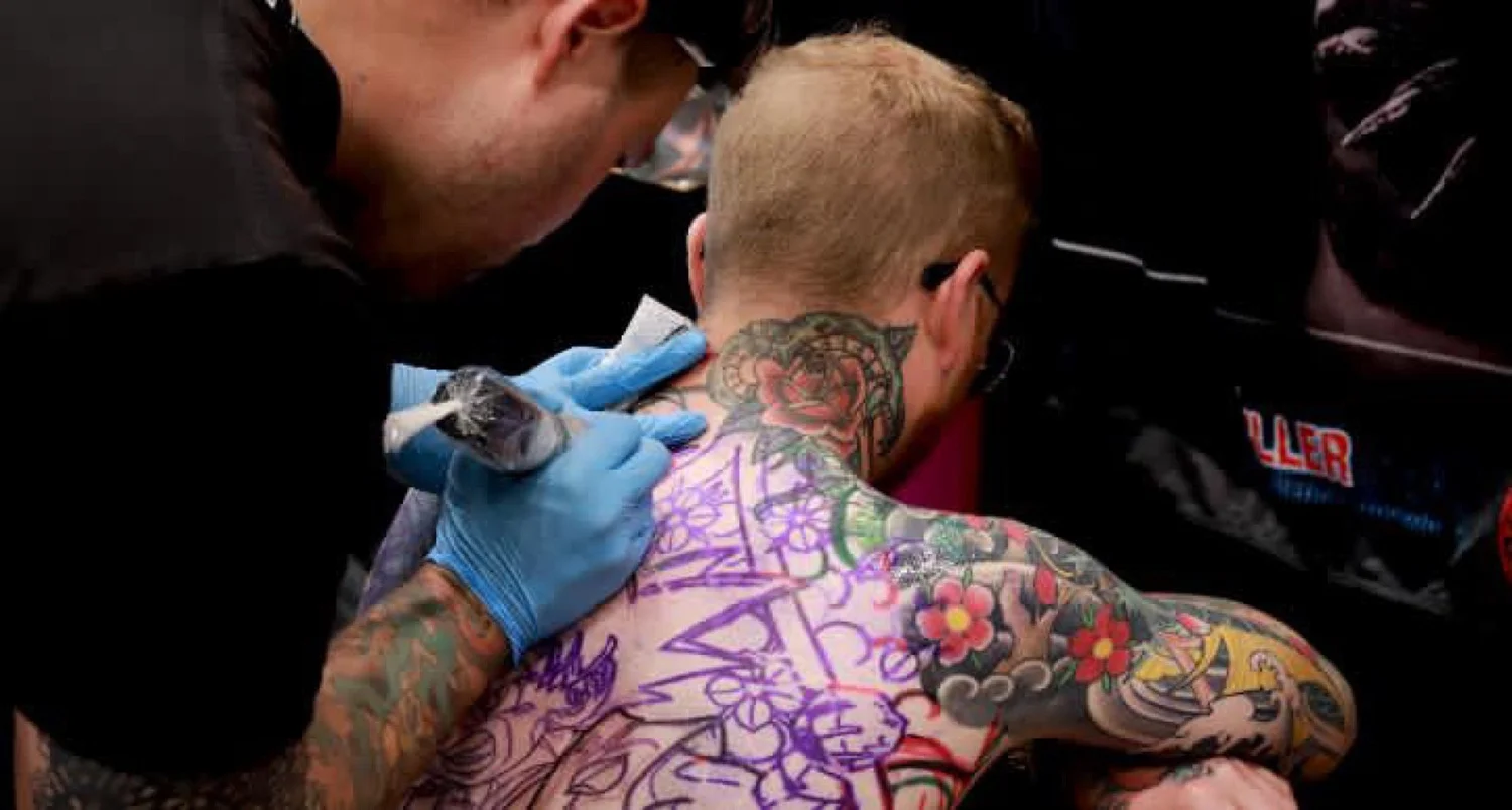 Nicklas tattooing Levi’s upper back during the convention session