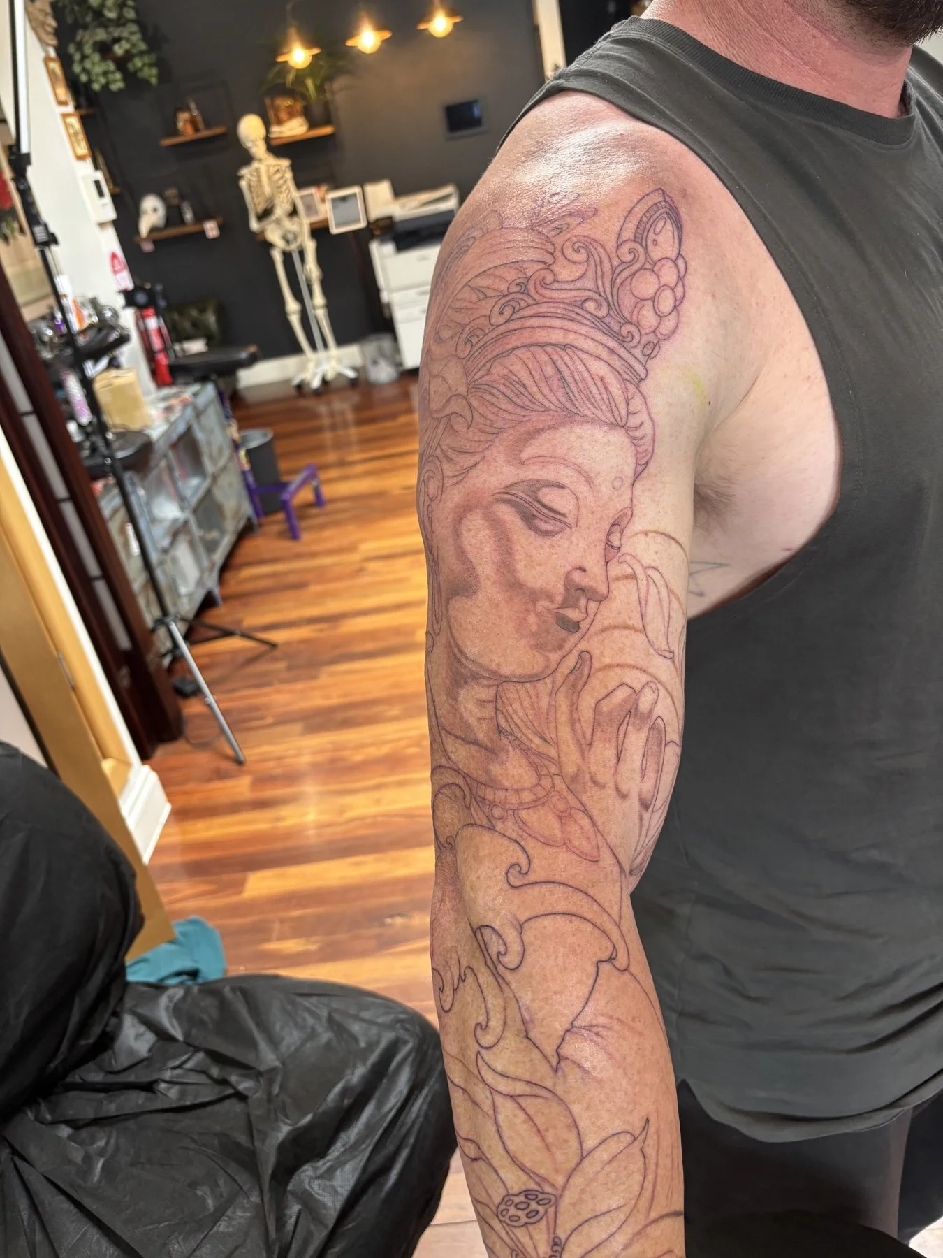 Buddha and lotus sleeve after the initial grey line session on the outer arm